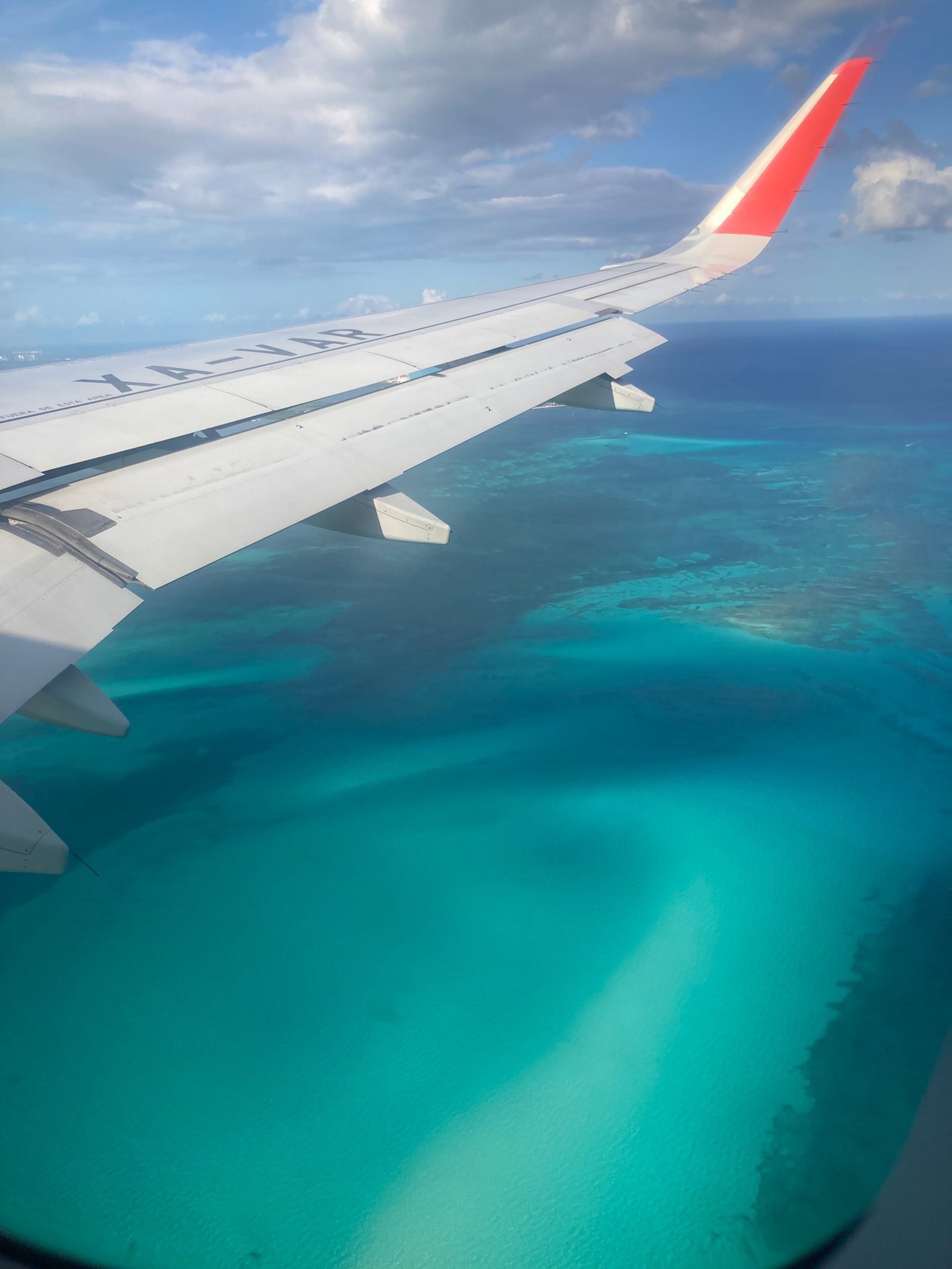 the wing of an airplane flying over the ocean