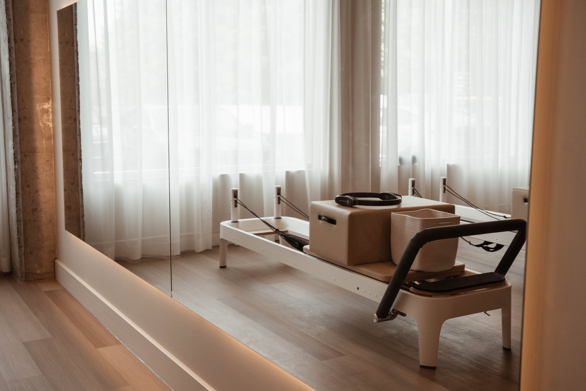 woman in black and white floral brassiere and black pants kneeling on pink yoga mat