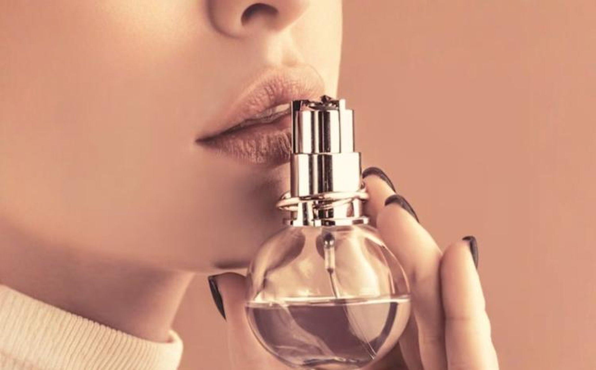person holding clear glass bottle