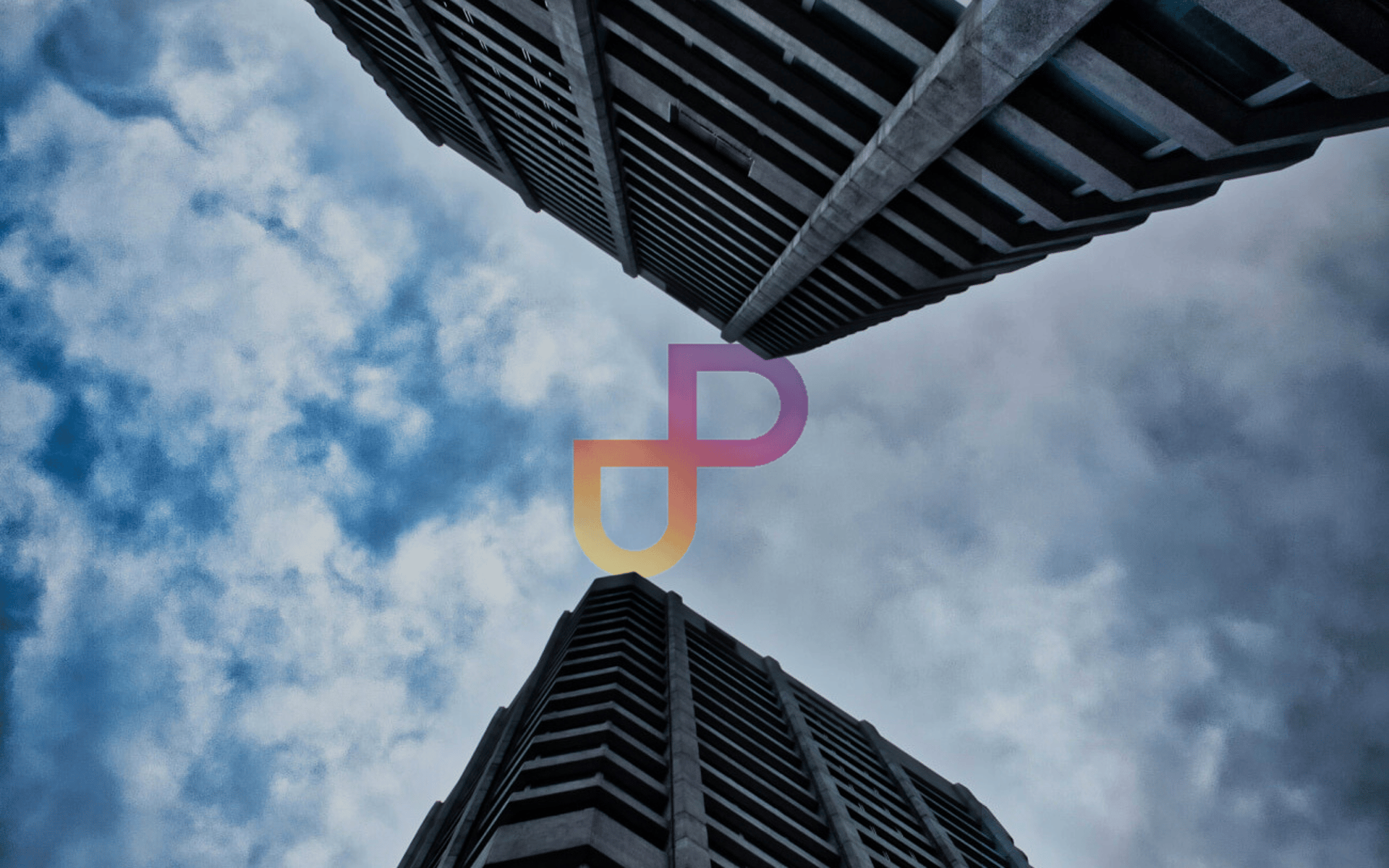 looking up at two tall buildings in a cloudy sky