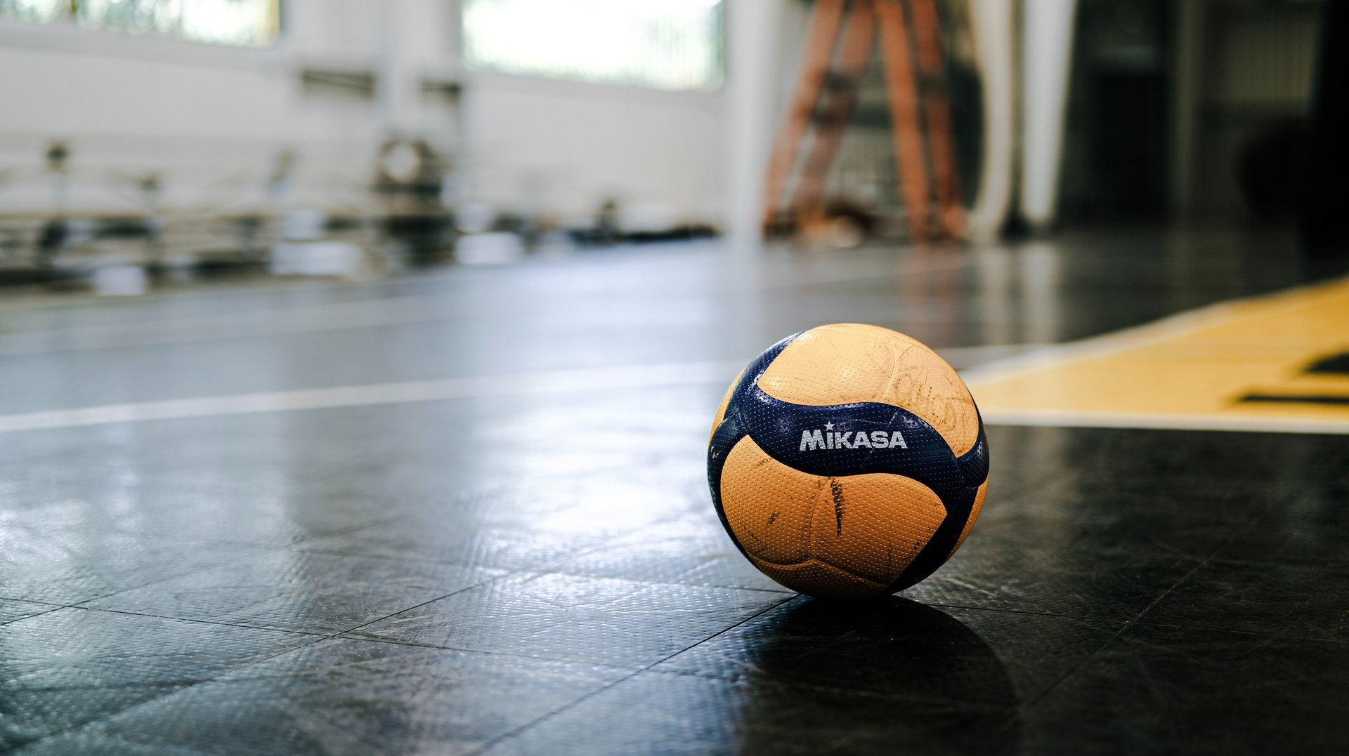 yellow and white volleyball on brown sand during daytime