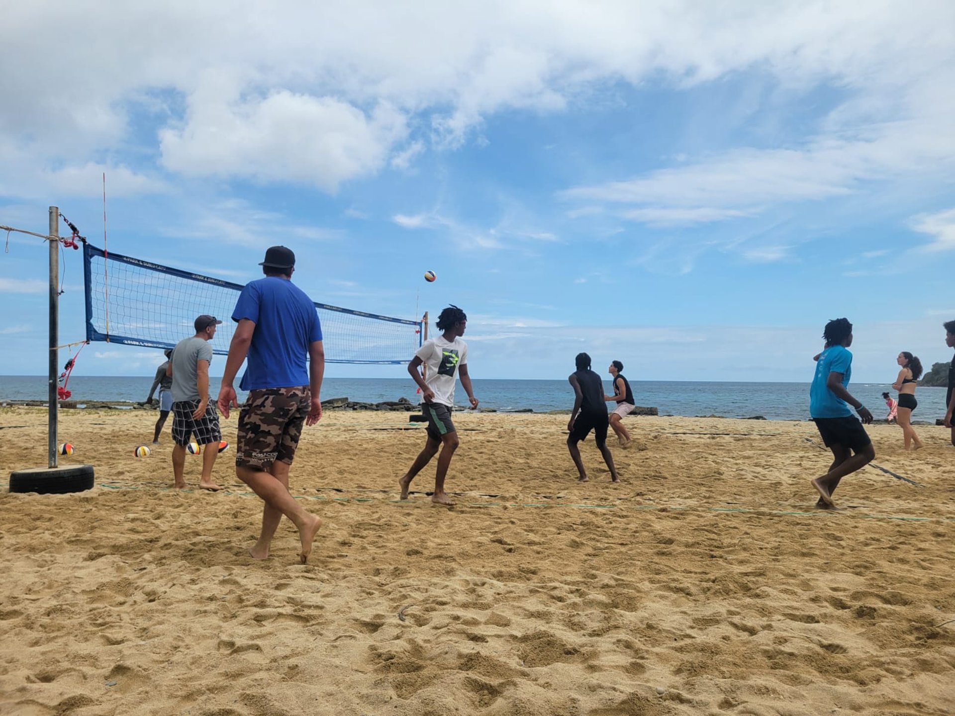 yellow and white volleyball on white sand during daytime