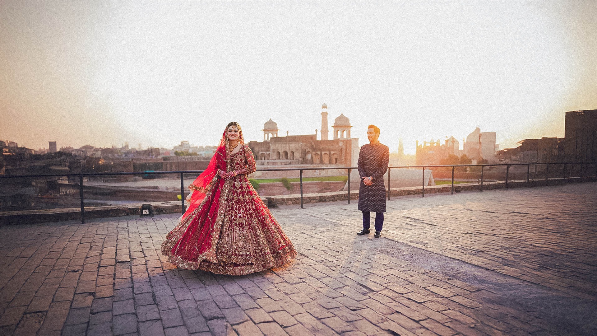 a bride and groom walking on a hill