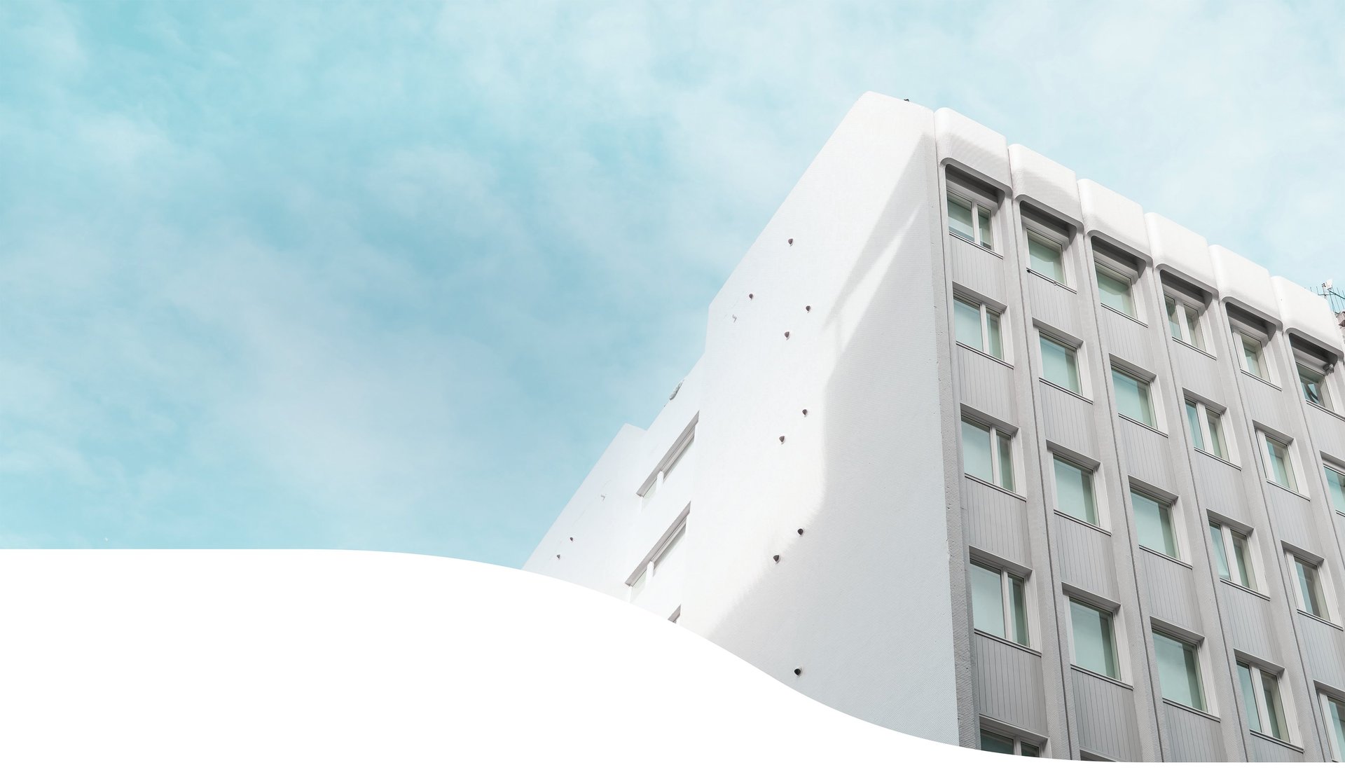 an abstract photo of a curved building with a blue sky in the background