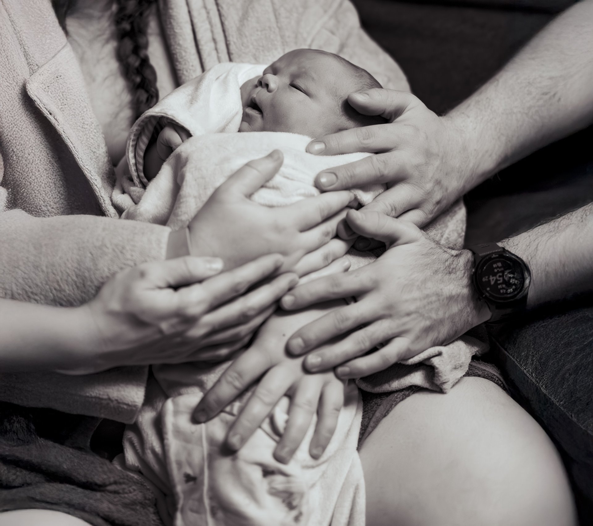 Art of Birth family hands on the baby