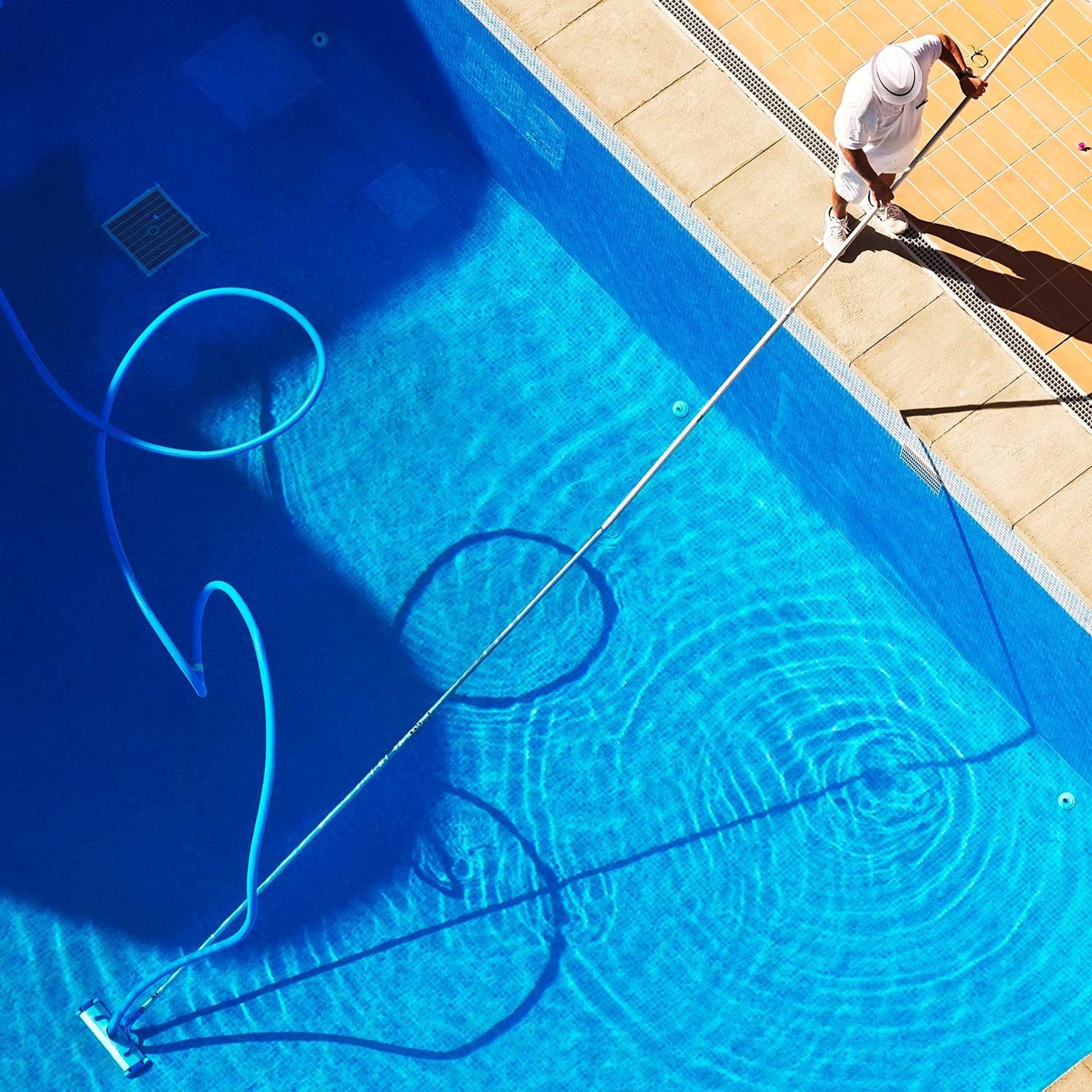 Vertical view of a luxurious, crystal-clear swimming pool with elegant tile edges
