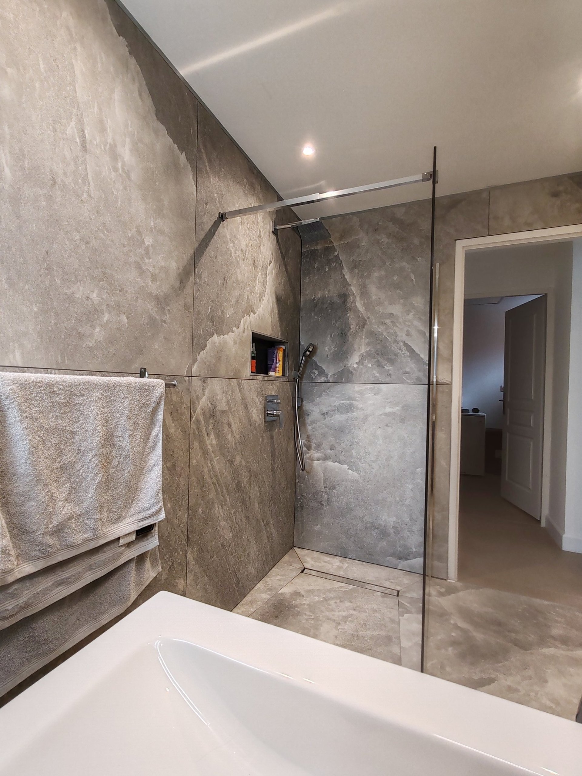 a bathroom with a marble wall and floor
