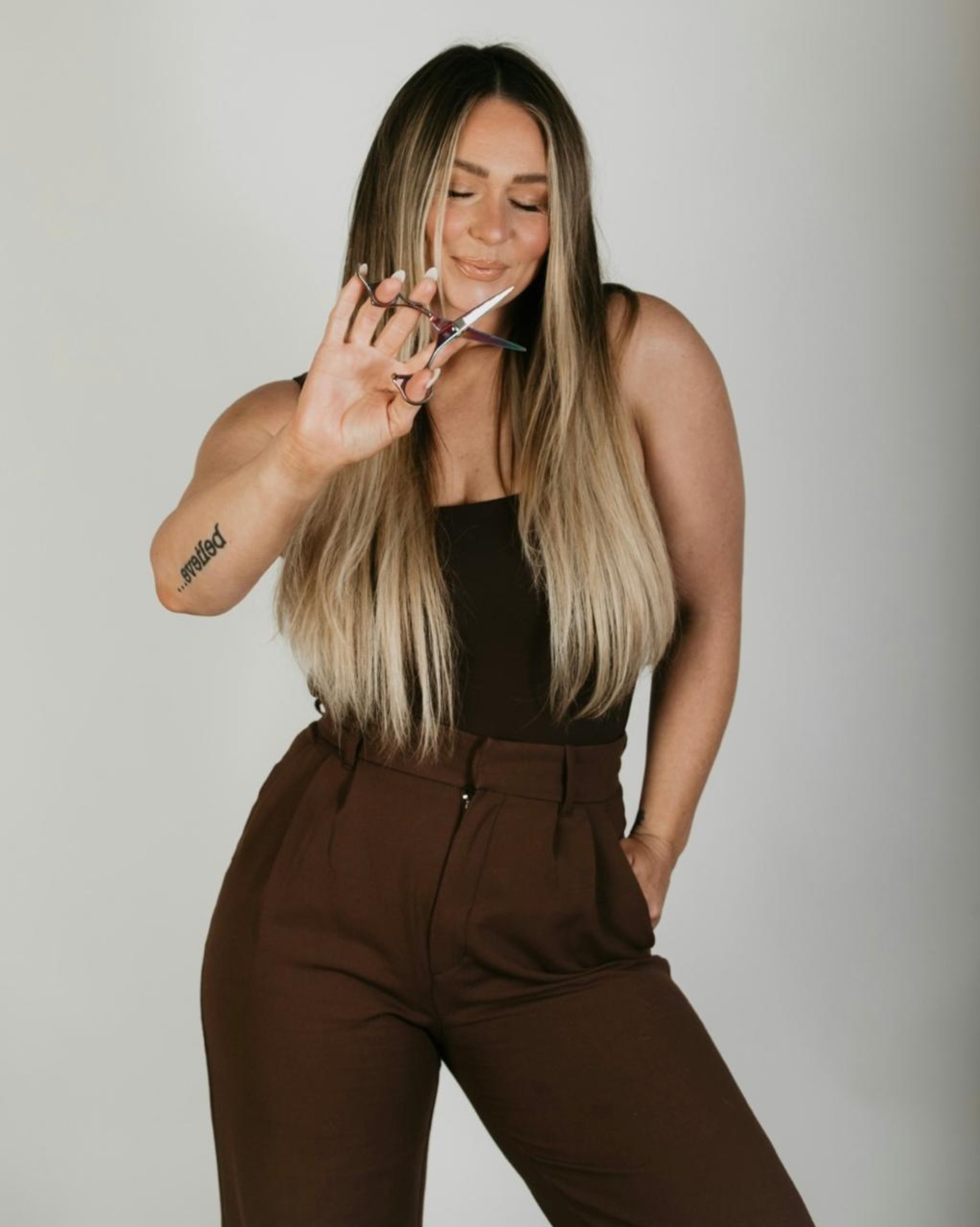 a woman in a brown jumpsuit smoking a cigarette