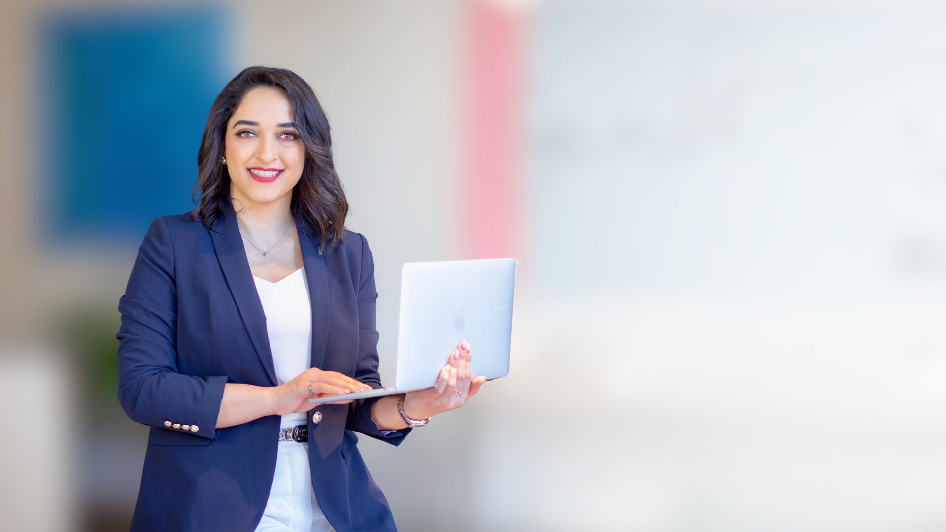 woman in teal t-shirt sitting beside woman in suit jacket