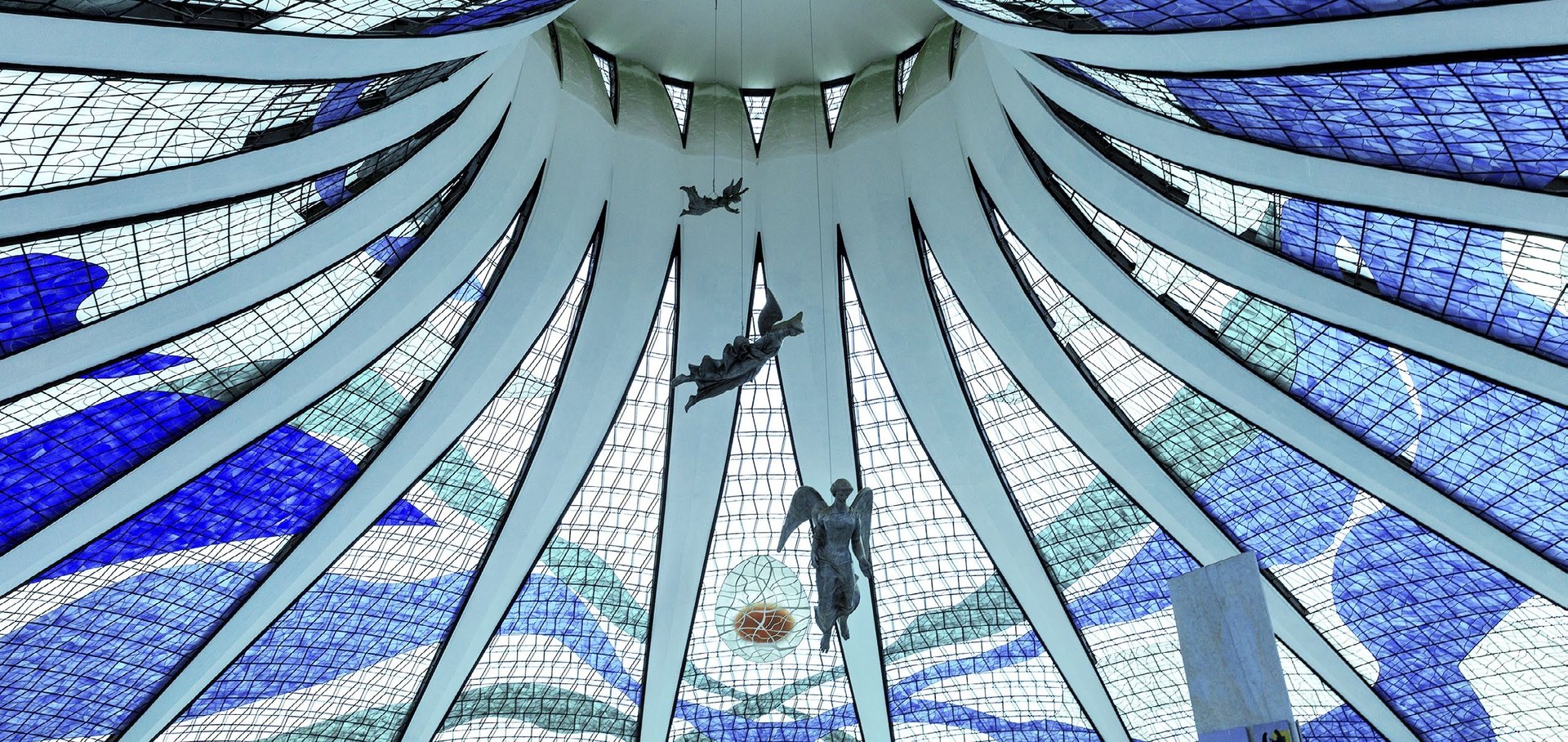 an abstract photo of a curved building with a blue sky in the background