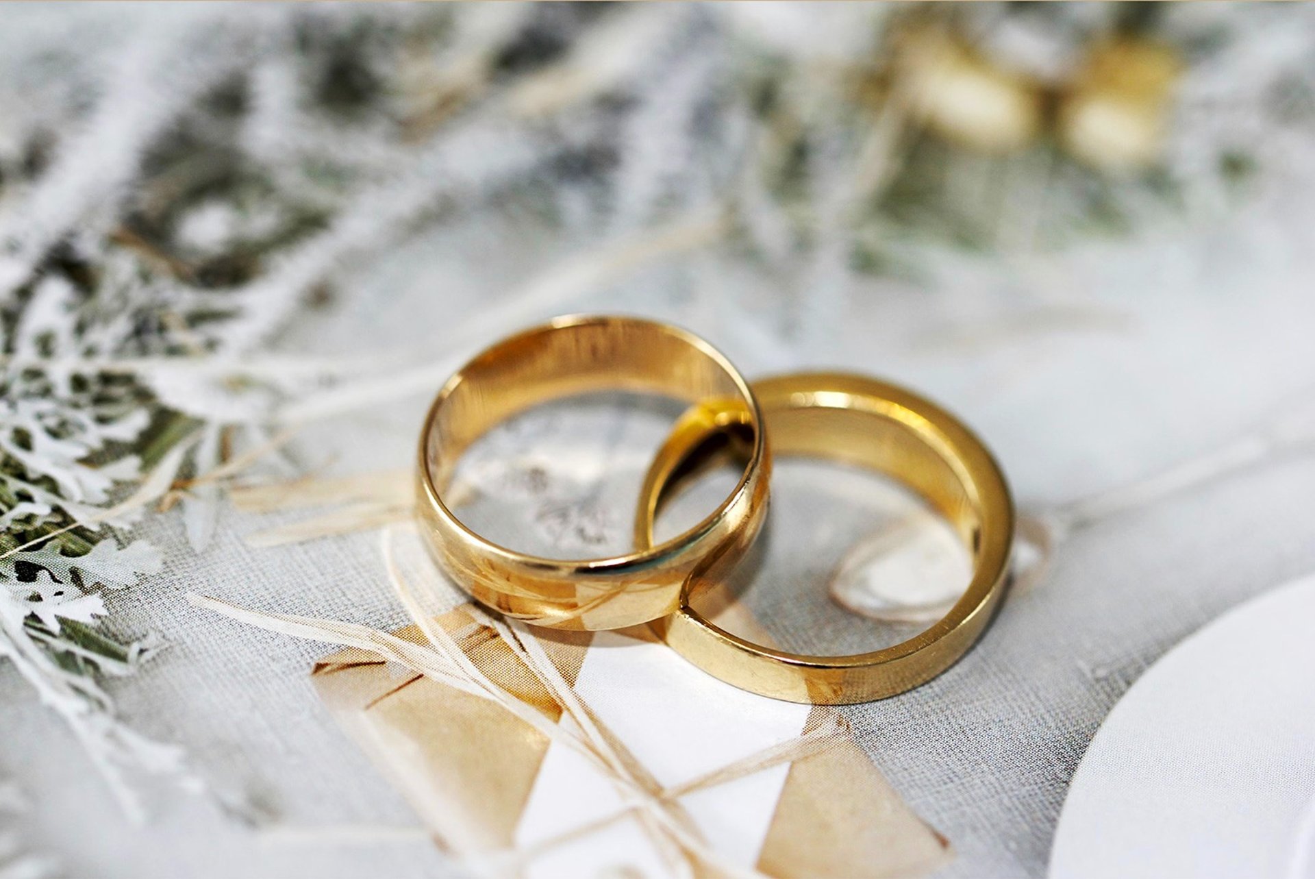 gold wedding band on white textile