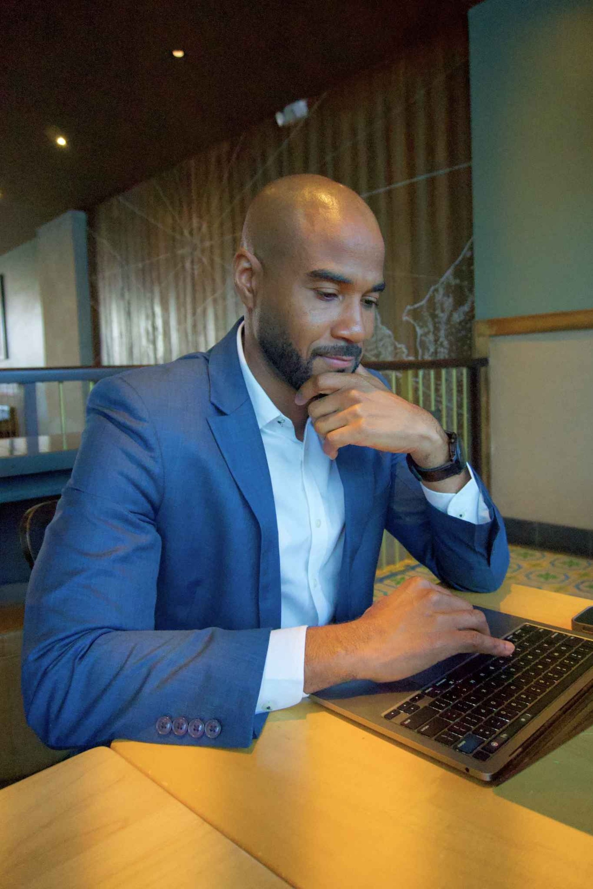 woman in black long sleeve shirt and blue denim jeans sitting on white concrete wall