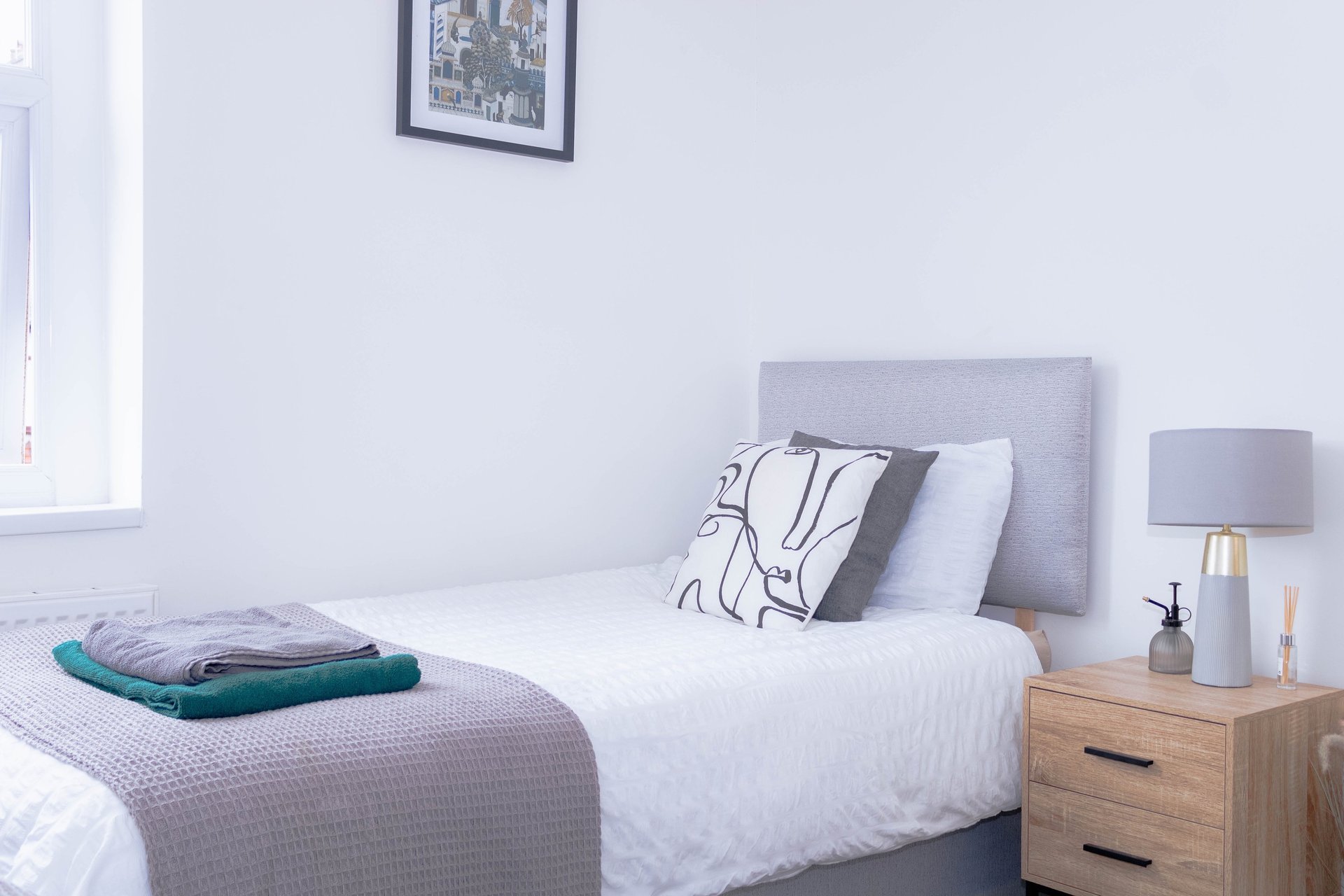 a bedroom with a bed and a plant in the corner
