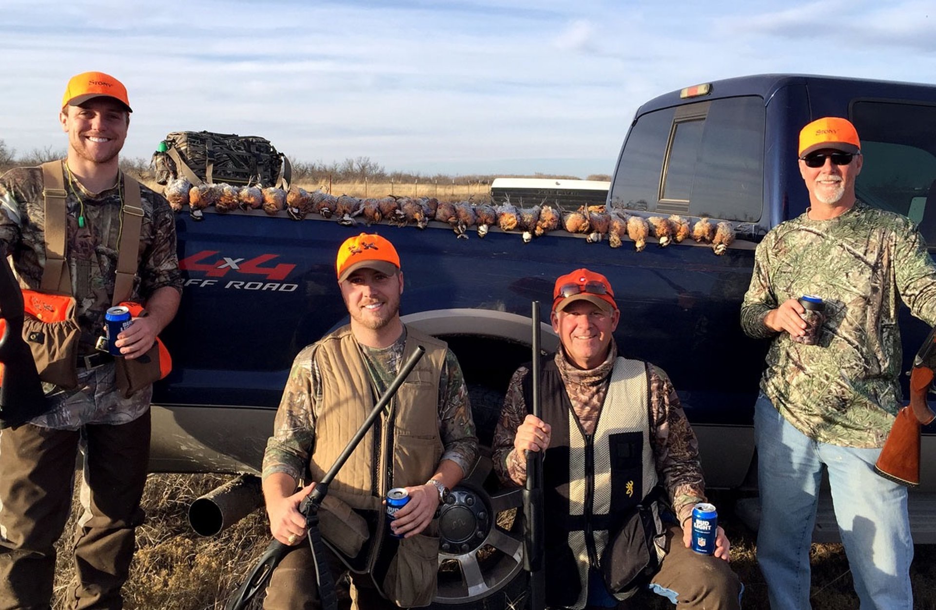 A group of four hunters celebrating a successful day of bird hunting in the Texas Panhandle.