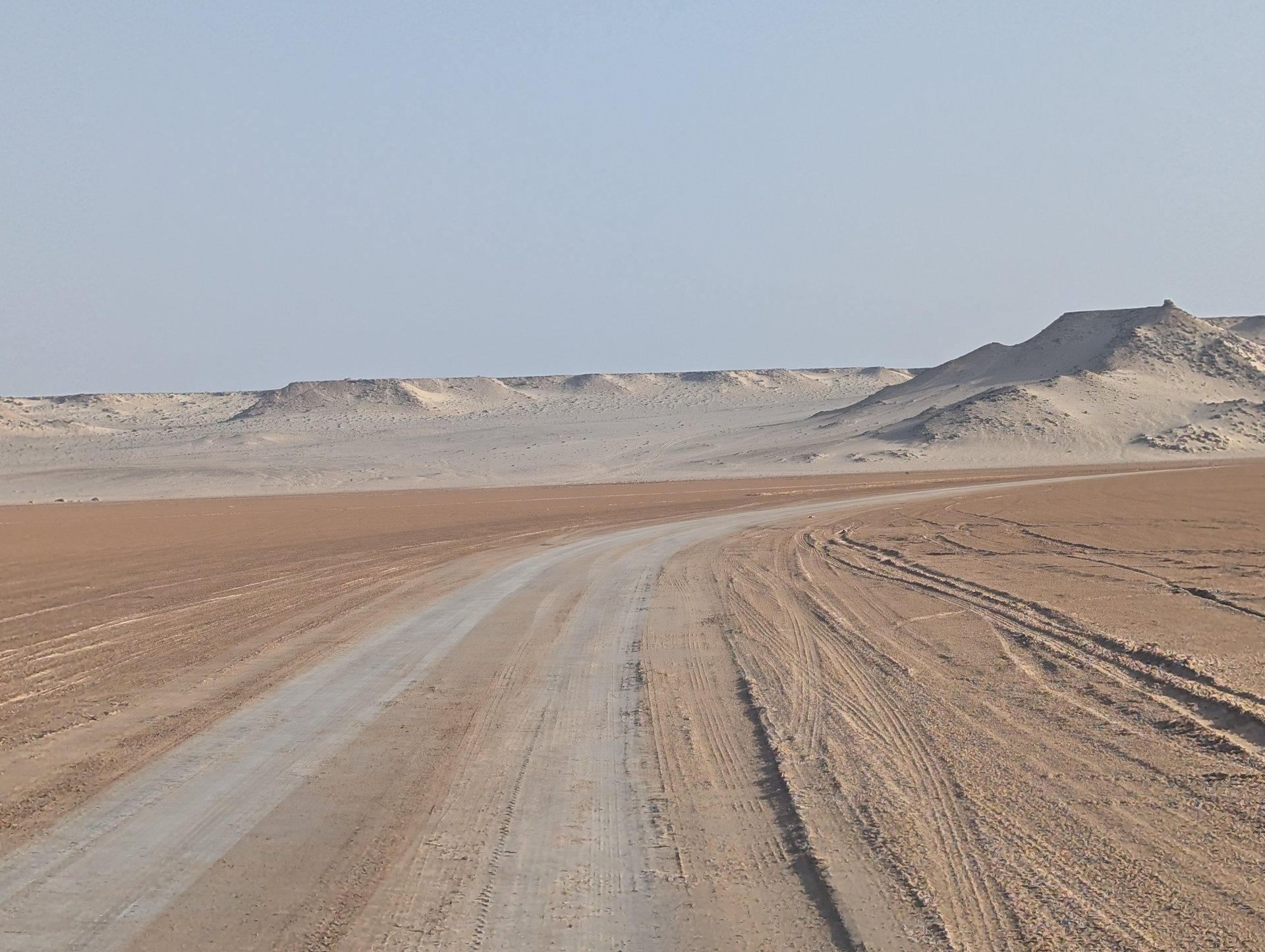 white and brown concrete building near green grass field during daytime