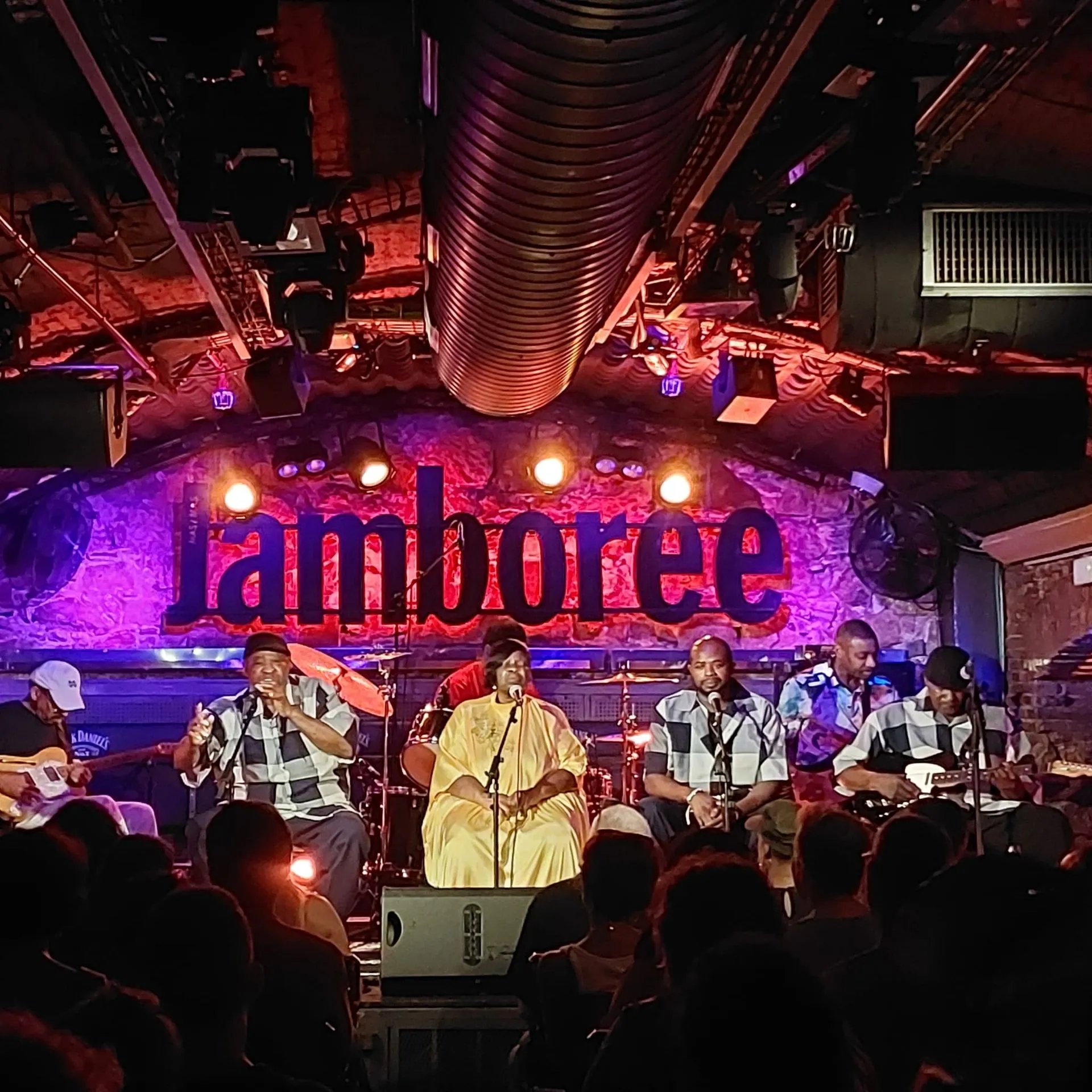 a large crowd of people in front of a stage with a sign