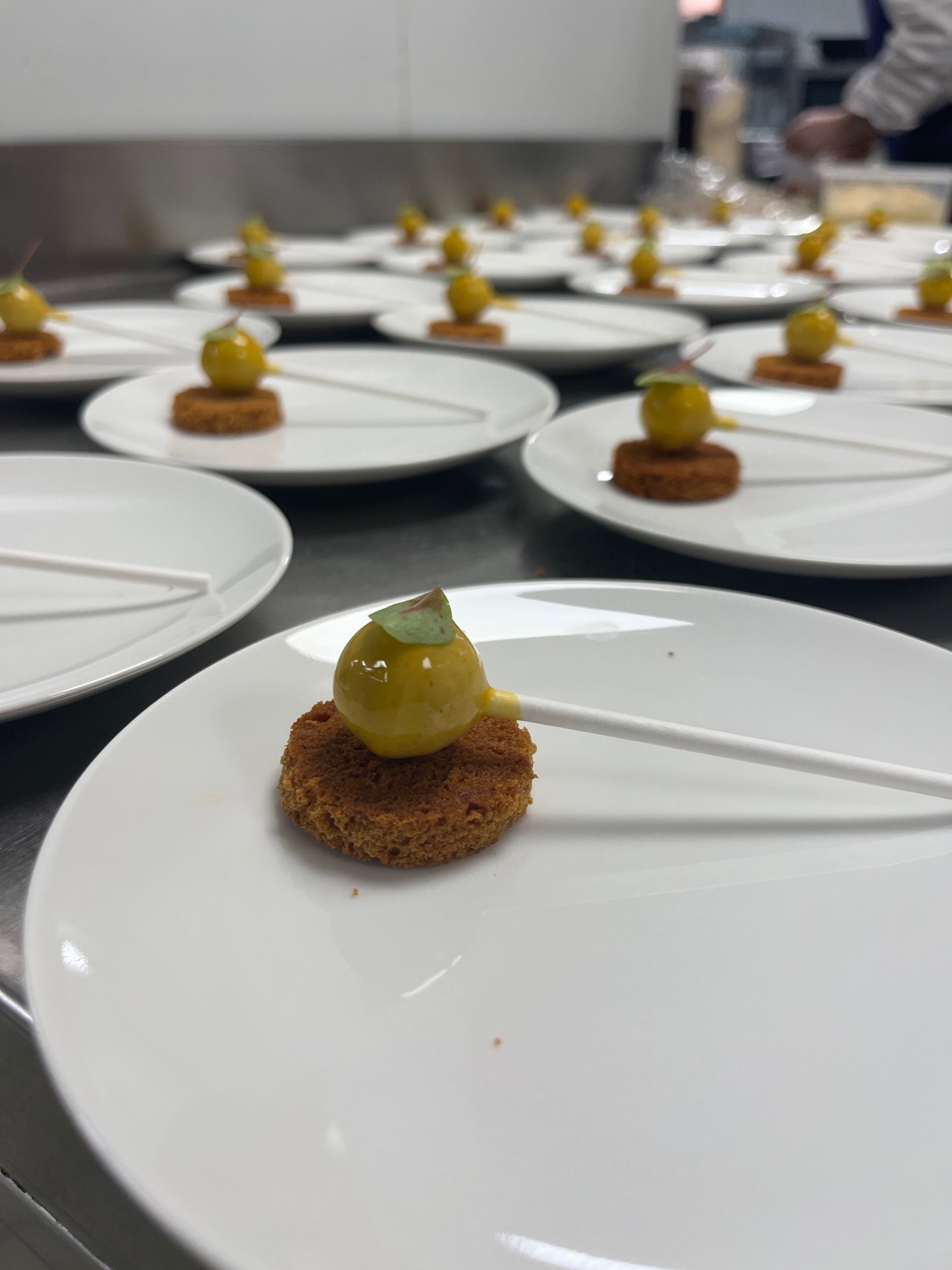 Dessert raffiné du Chef Menisy à Valenciennes : sucette sphérique à la mangue sur biscuit