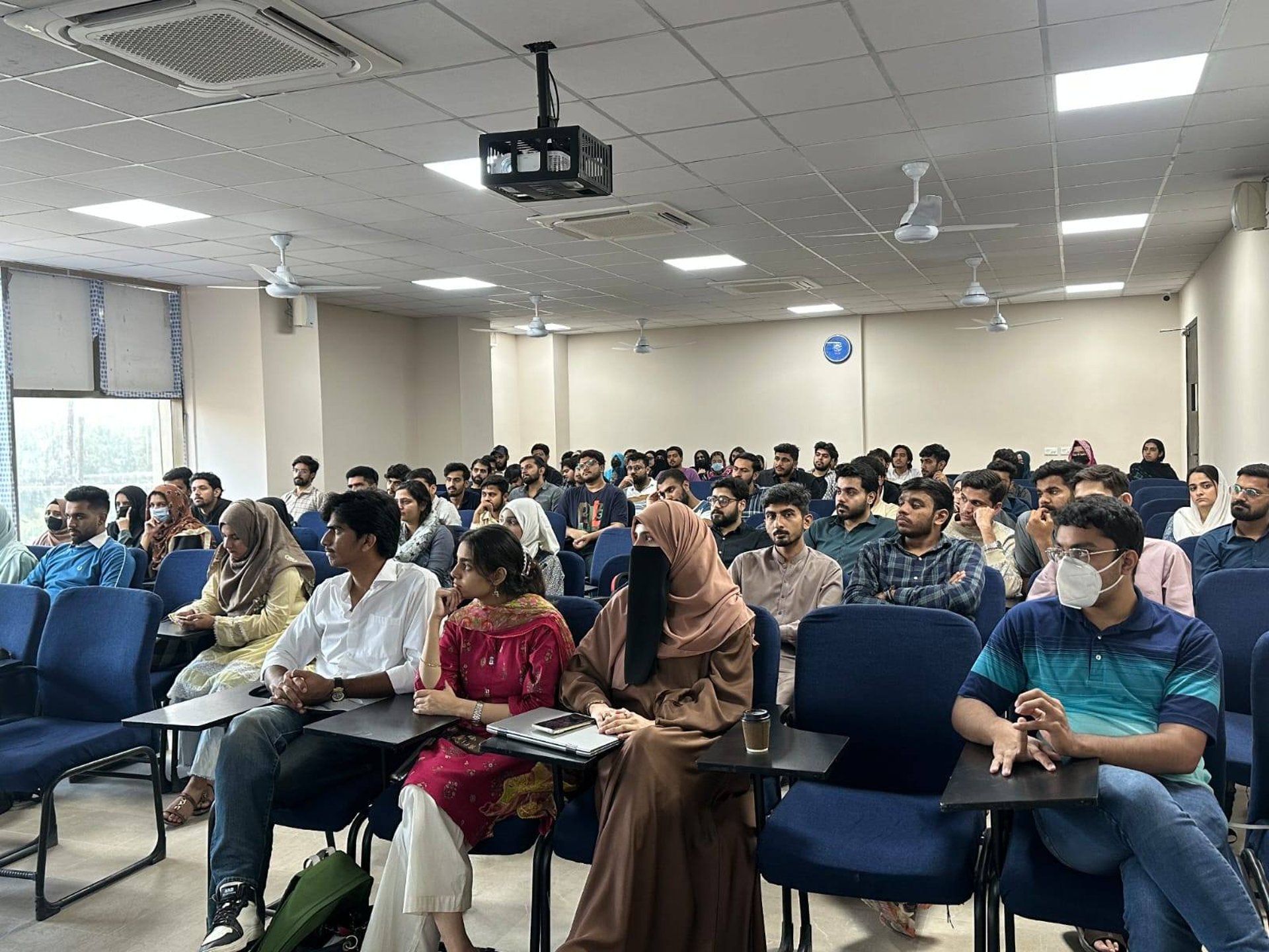 man standing in front of people sitting beside table with laptop computers