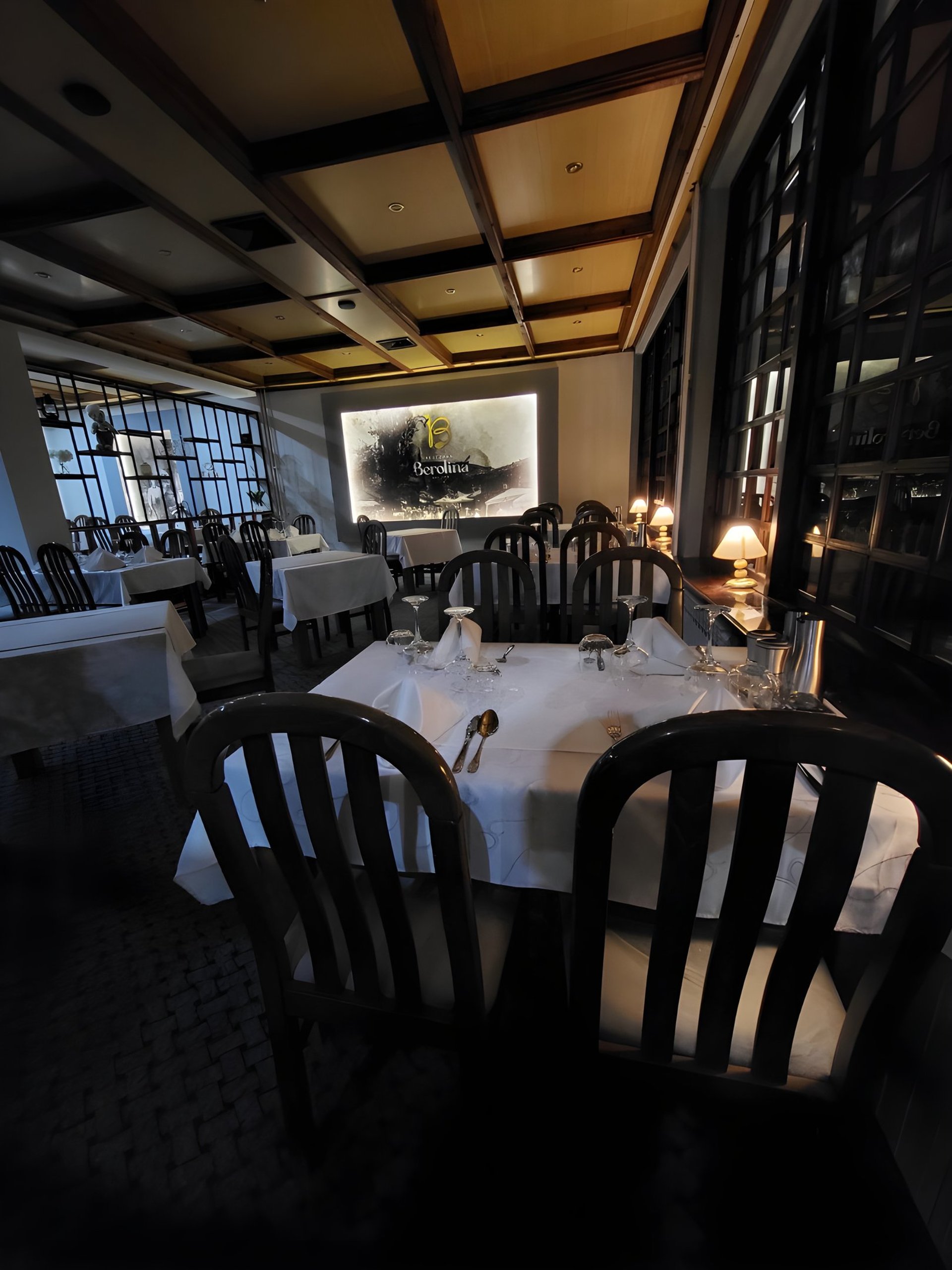 bacon strips and melted cheese topped fries on oval white and blue platter with gray stainless steel forks