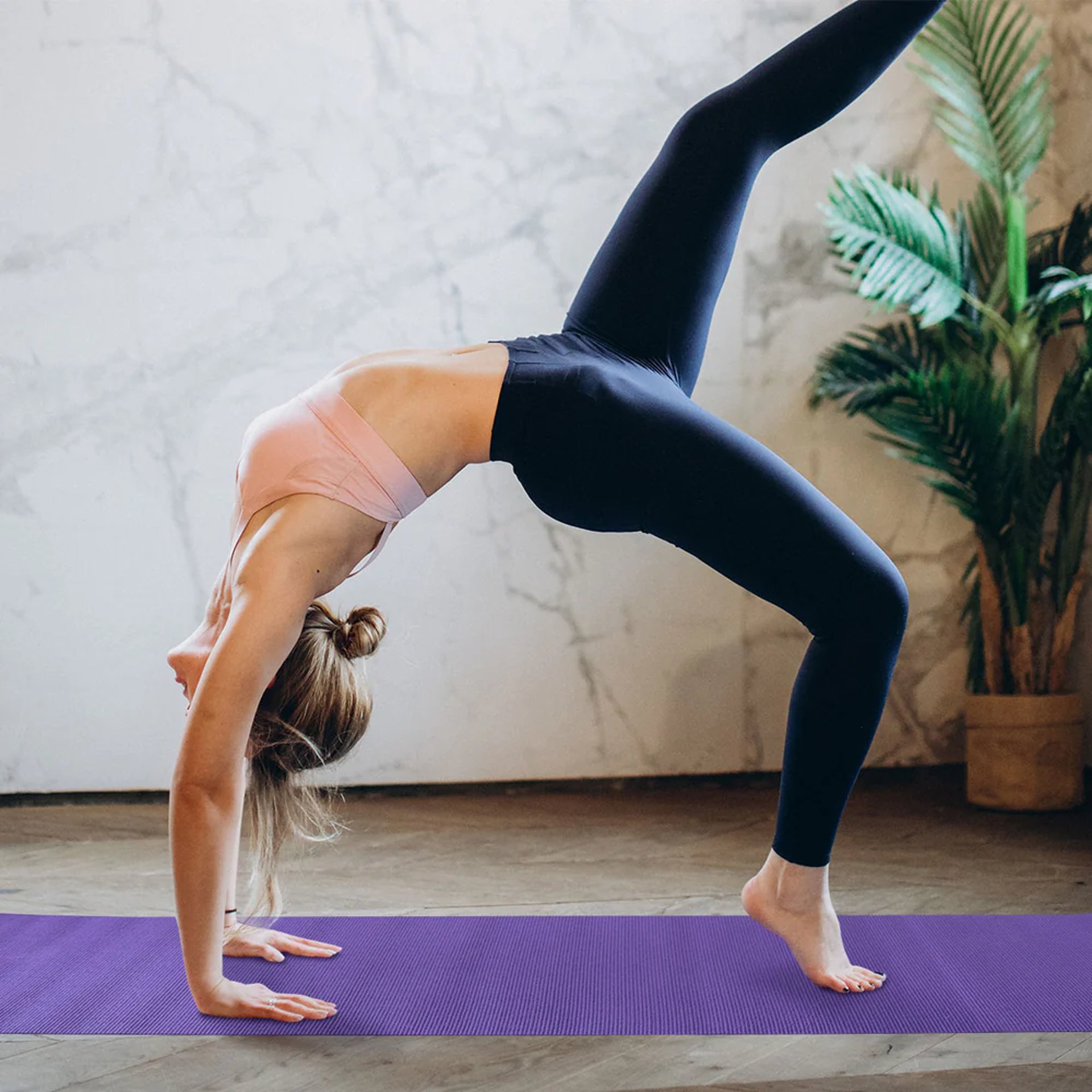 woman in white crop-top and black leggings doing yoga
