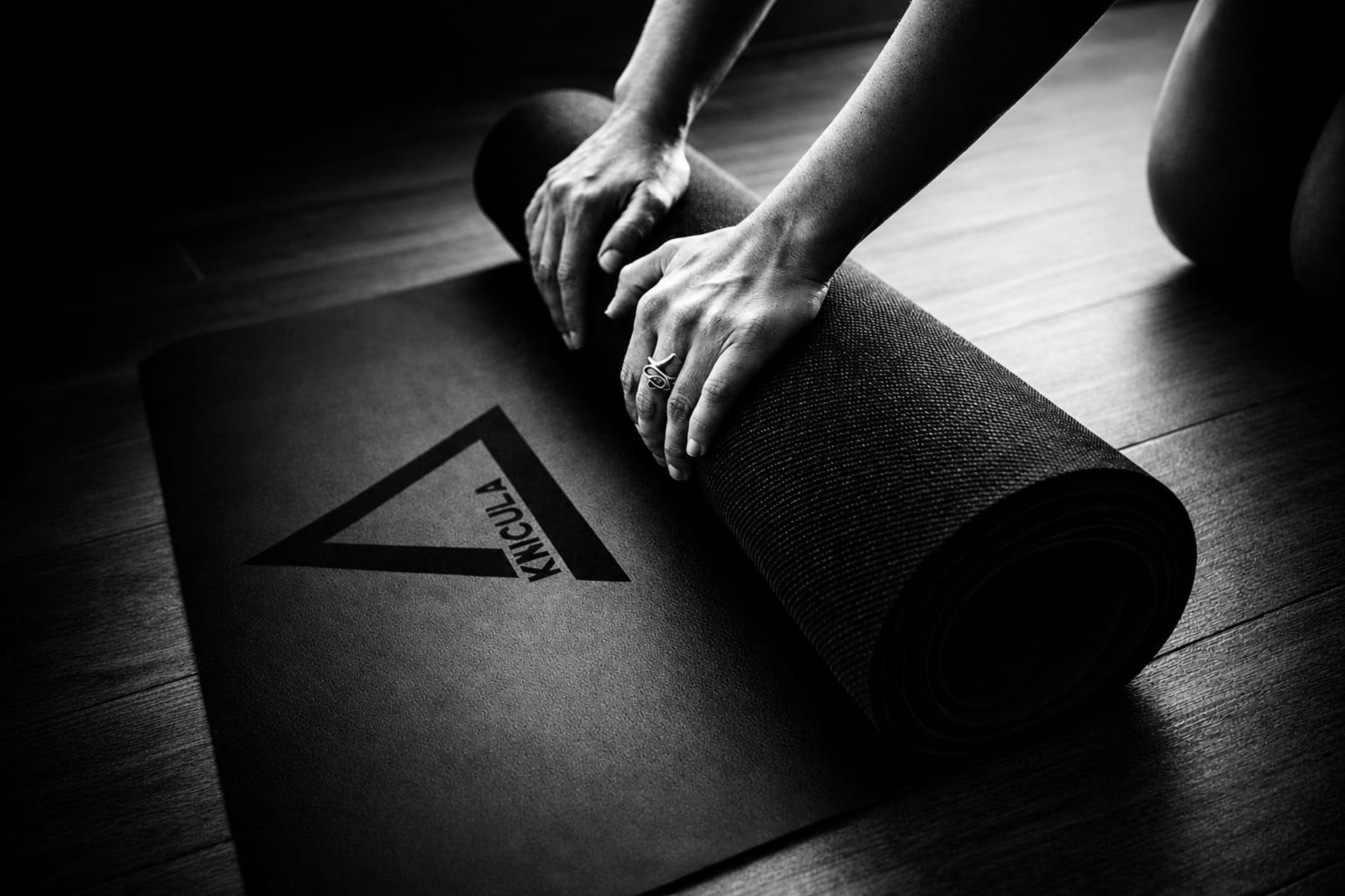 woman in black tank top and black pants bending her body on floor