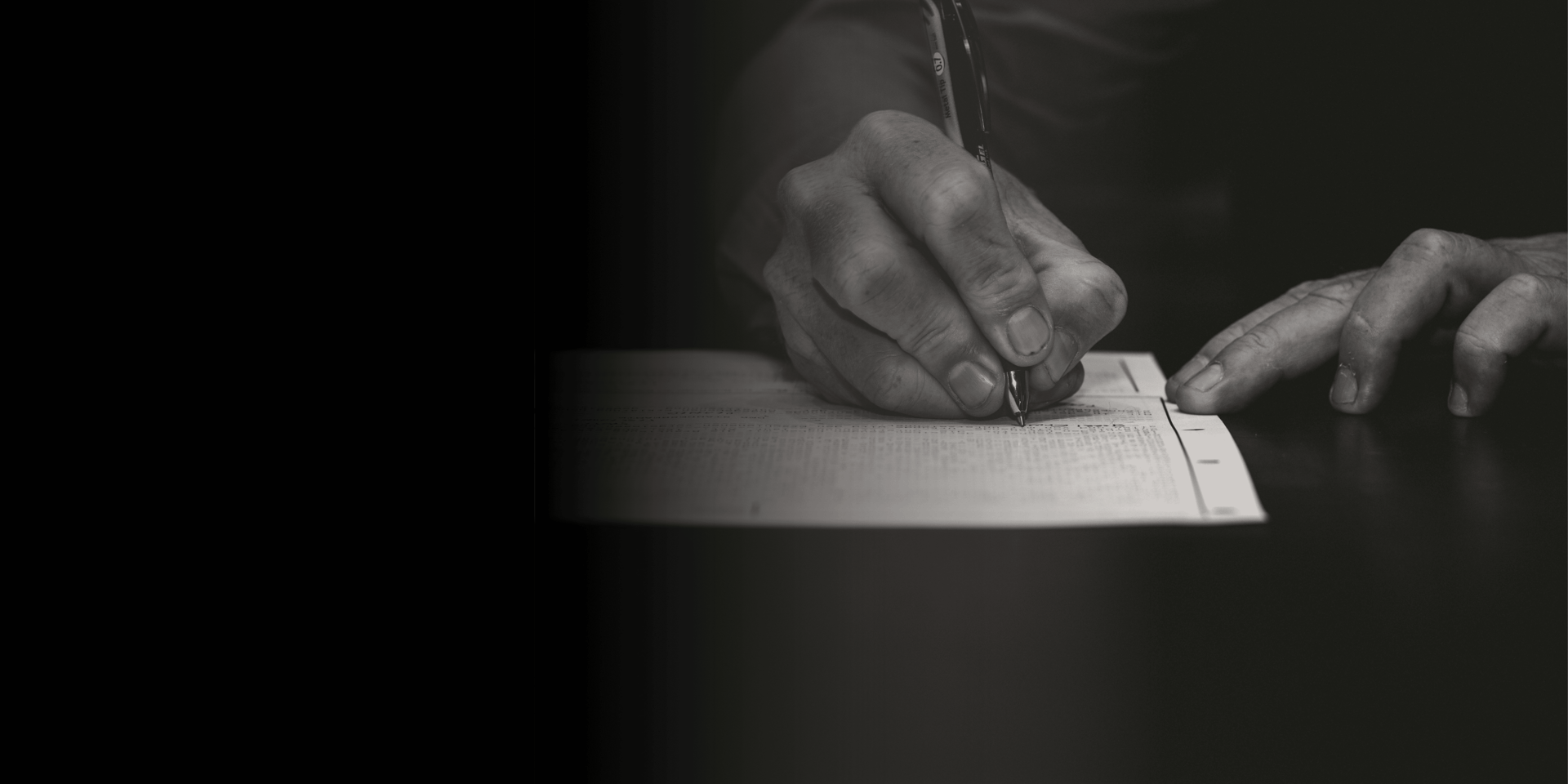 man writing on paper