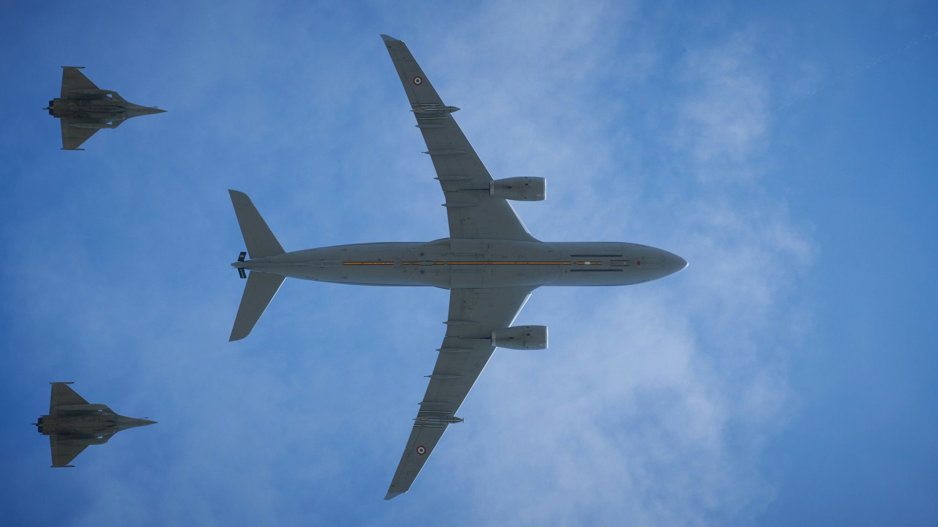 Airplane cargo door opening with contrails in sky