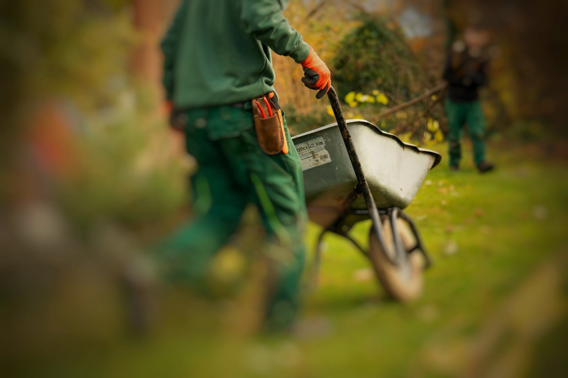 A man pulling a wheelbarrow with a wheel