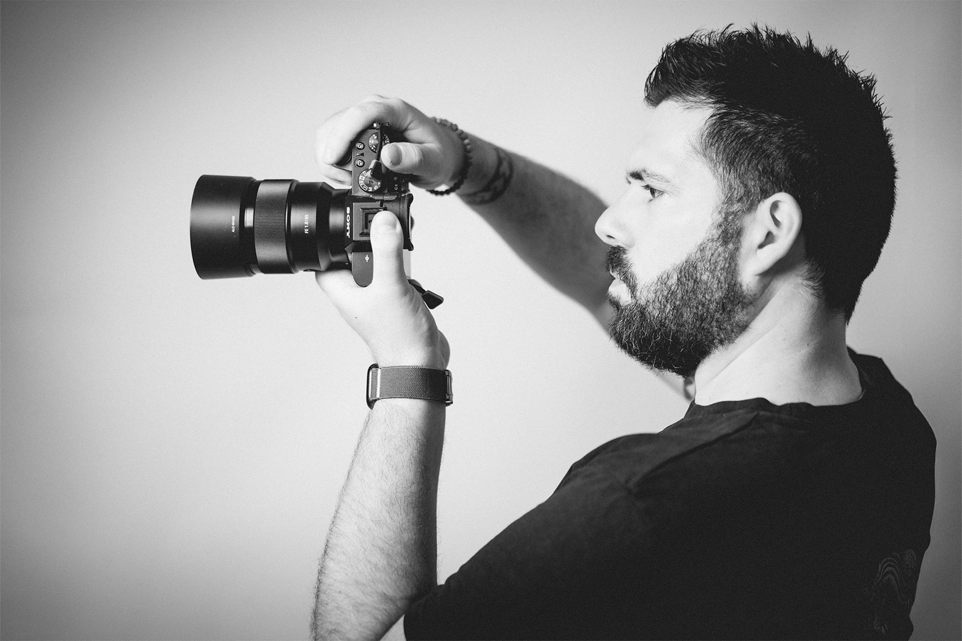 Portrait en noir et blanc de Cyril Steau, photographe à Paris, en pleine prise de vue avec un appareil photo professionnel.