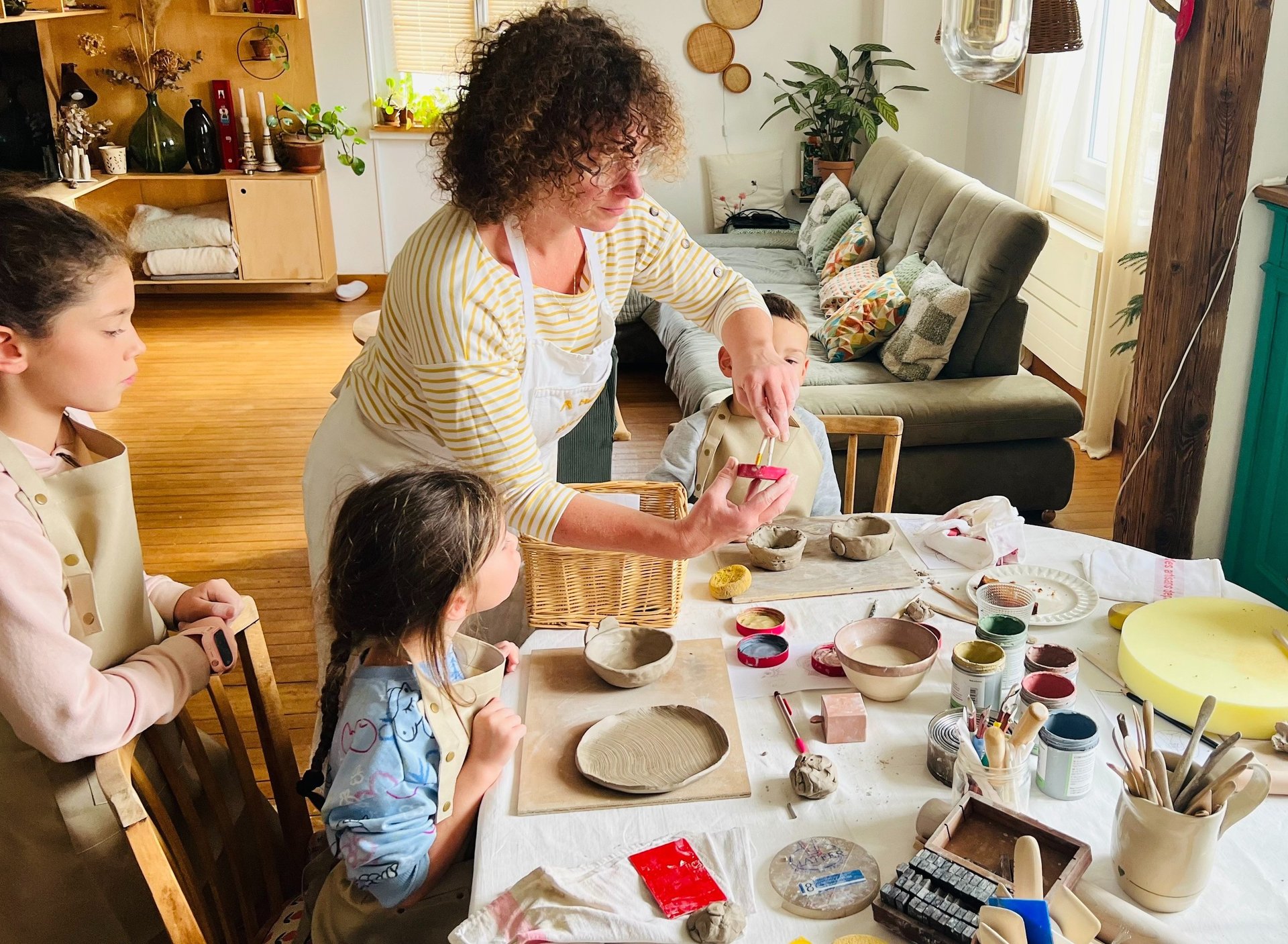 a boy is painting a bowl on a table