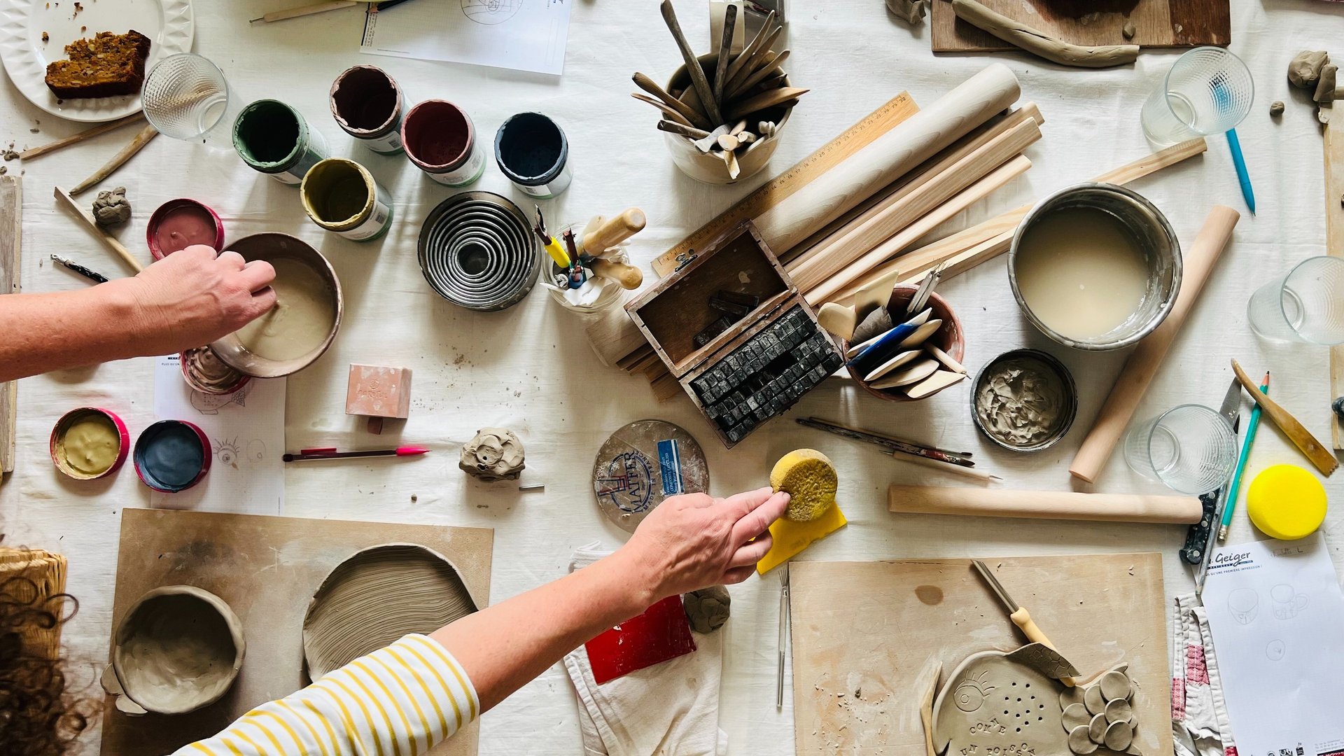 Ceramic pottery and plates sit on a windowsill.