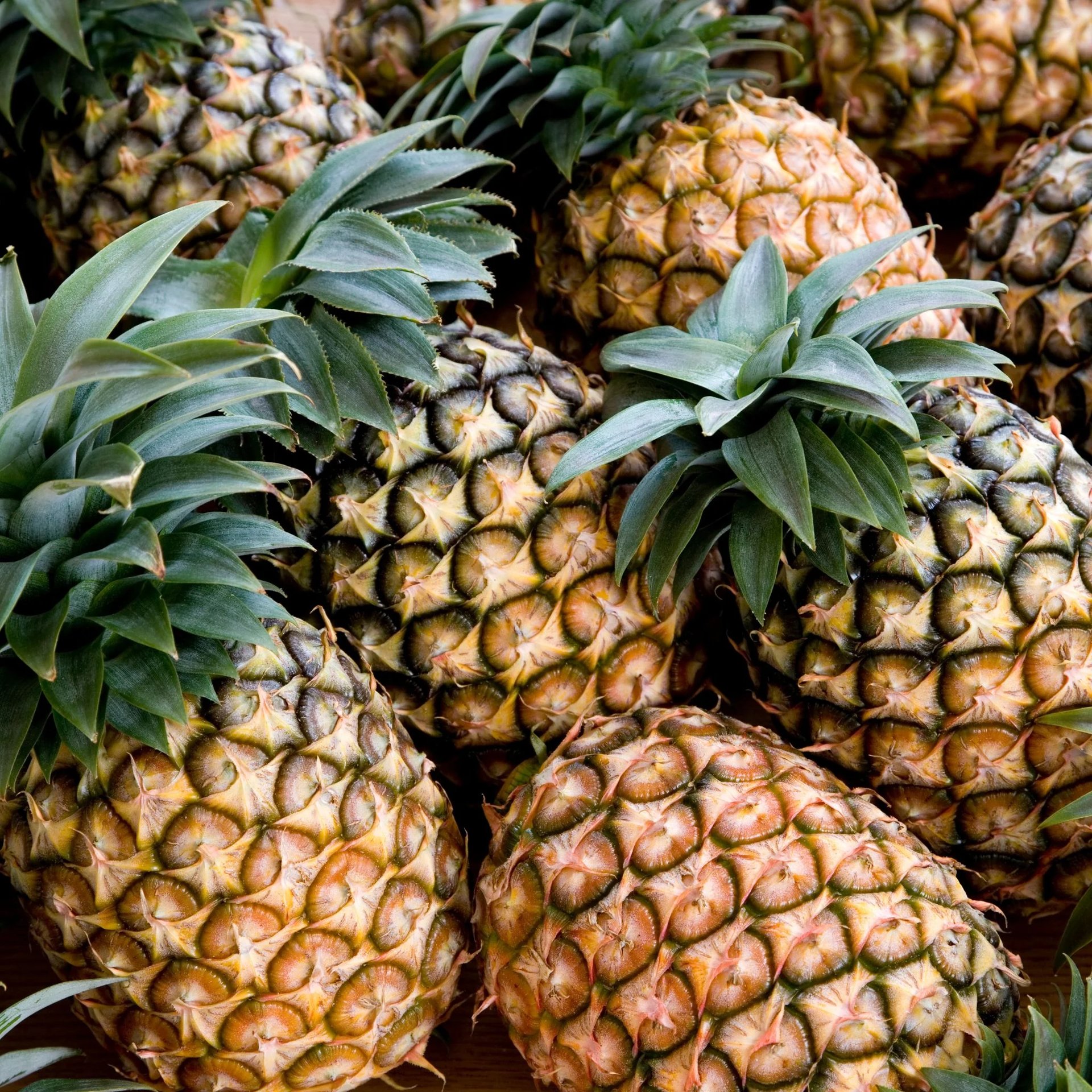 a pile of pineapples sitting on top of a wooden table