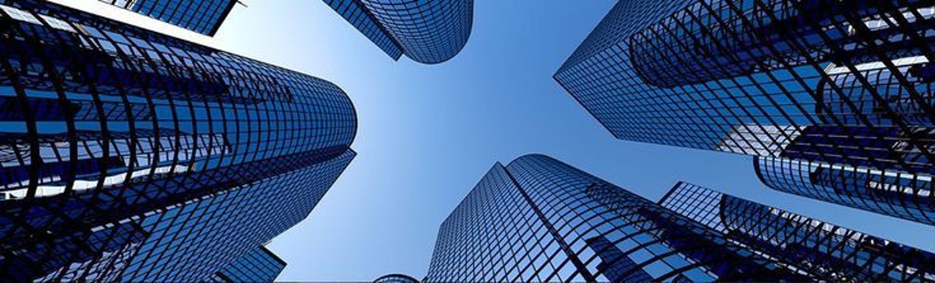 an abstract photo of a curved building with a blue sky in the background
