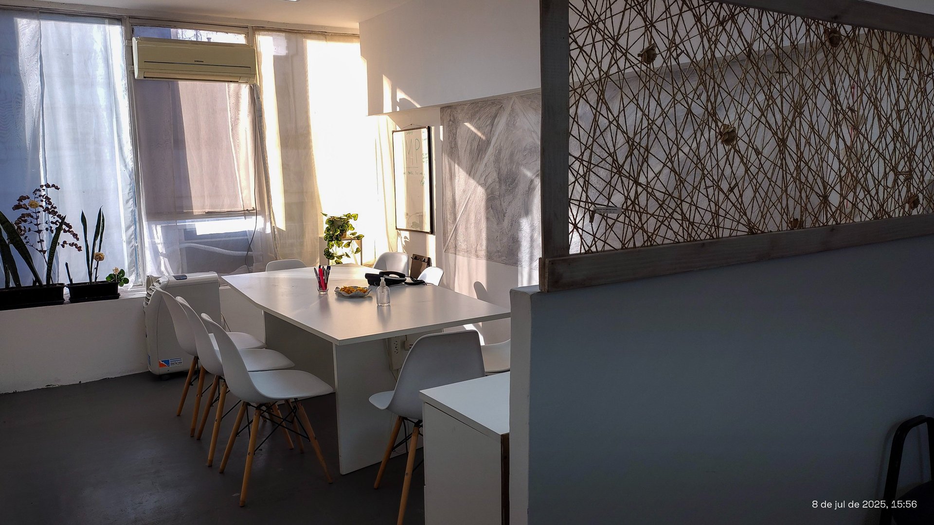 Sala de firmas en Red de Llaves con mesa blanca, luz natural y detalles decorativos sobre la cómoda.