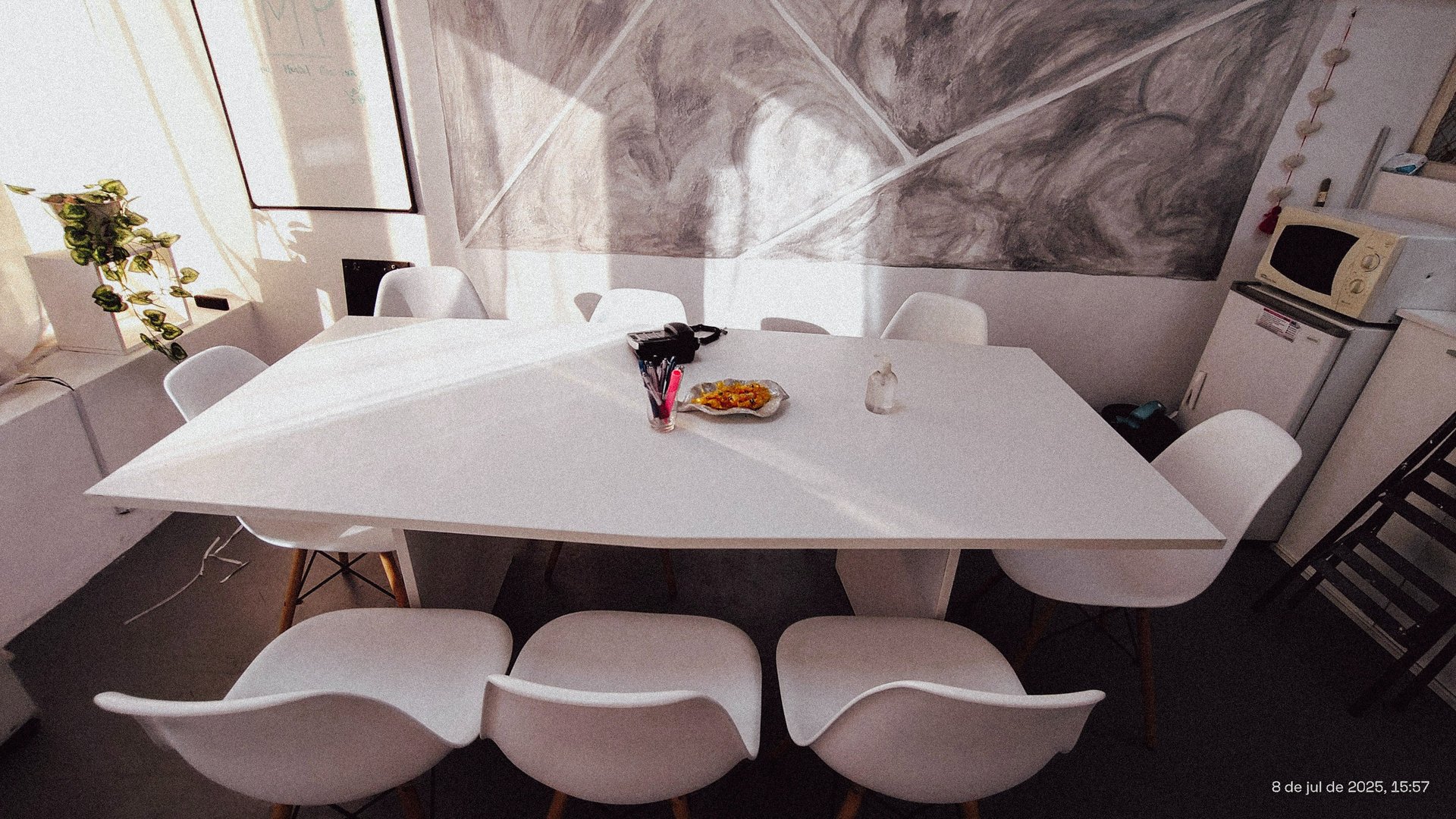 Sala de firmas en Red de Llaves con mesa blanca, decoración sobria y luz natural filtrada por cortinas.