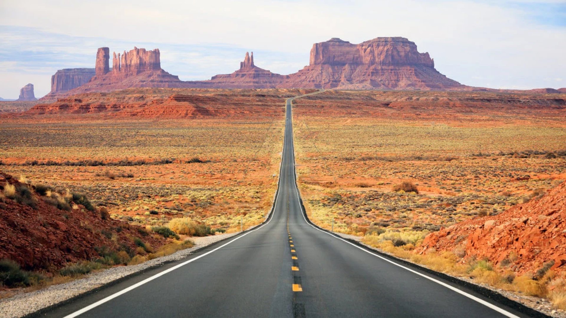 gray asphalt road between brown grass field during daytime