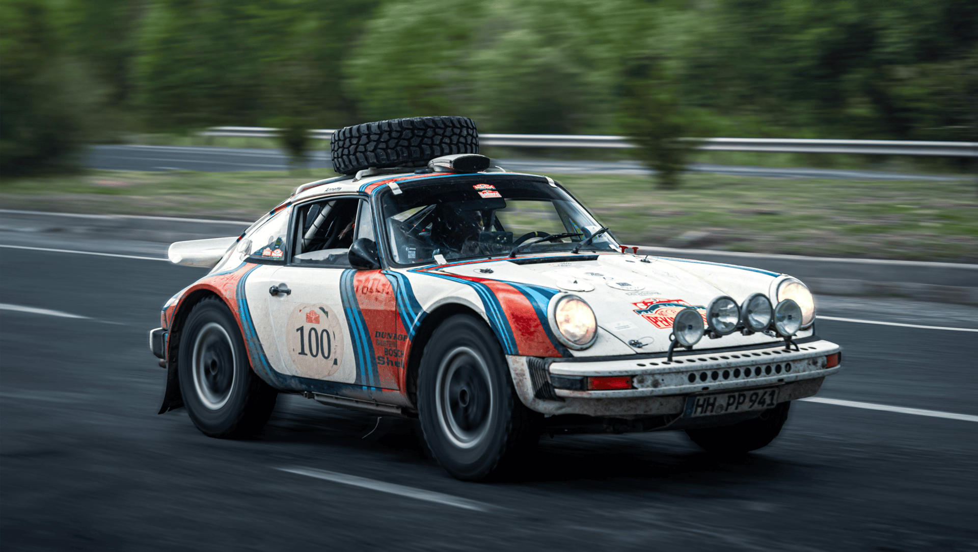 a white sports car parked on a brick road with trees and a building