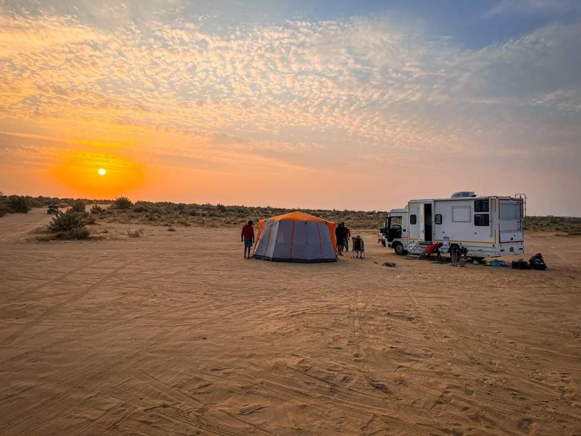 white and gray rv trailer on brown sand during night time