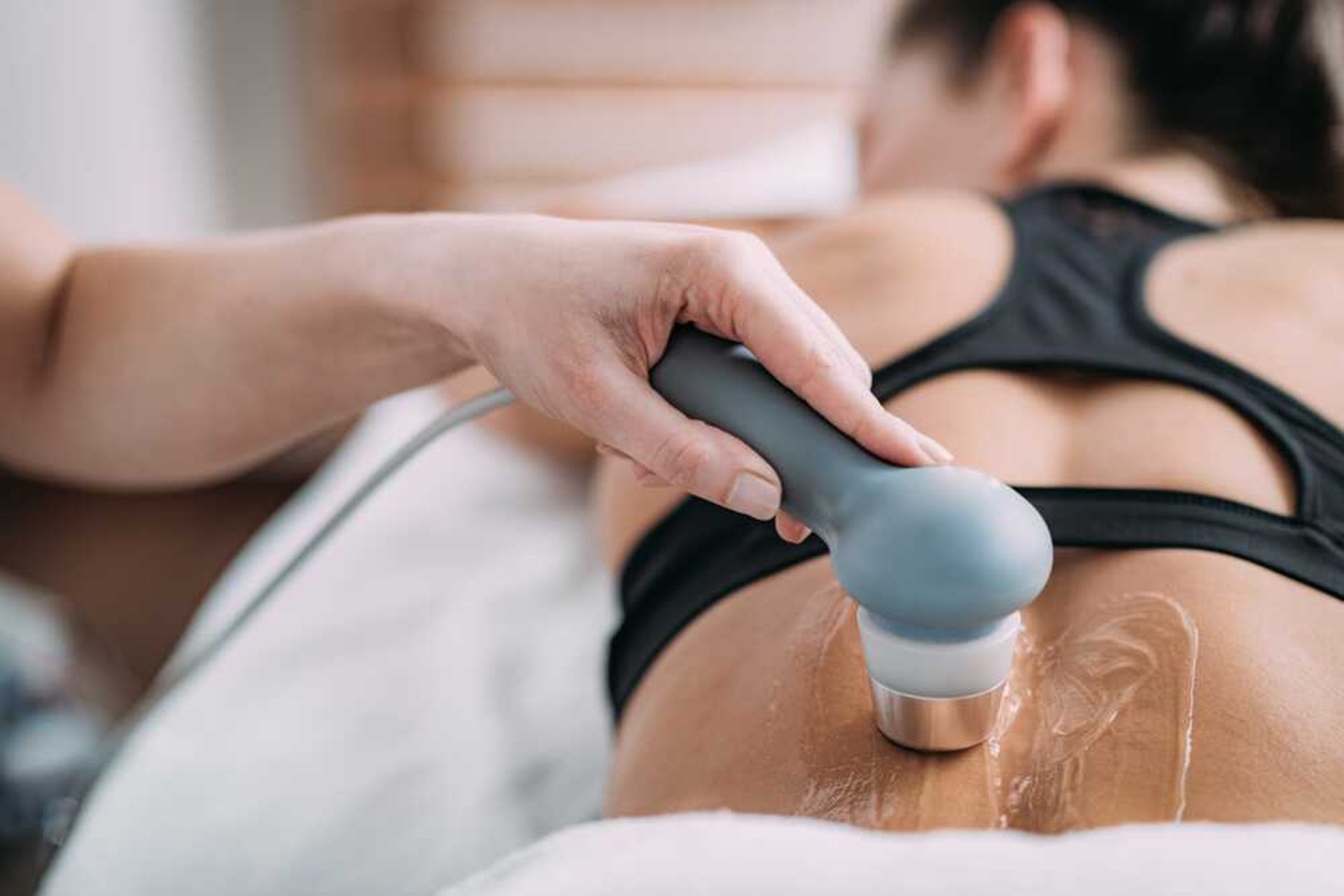 Woman receiving ultrasound physiotherapy on her back