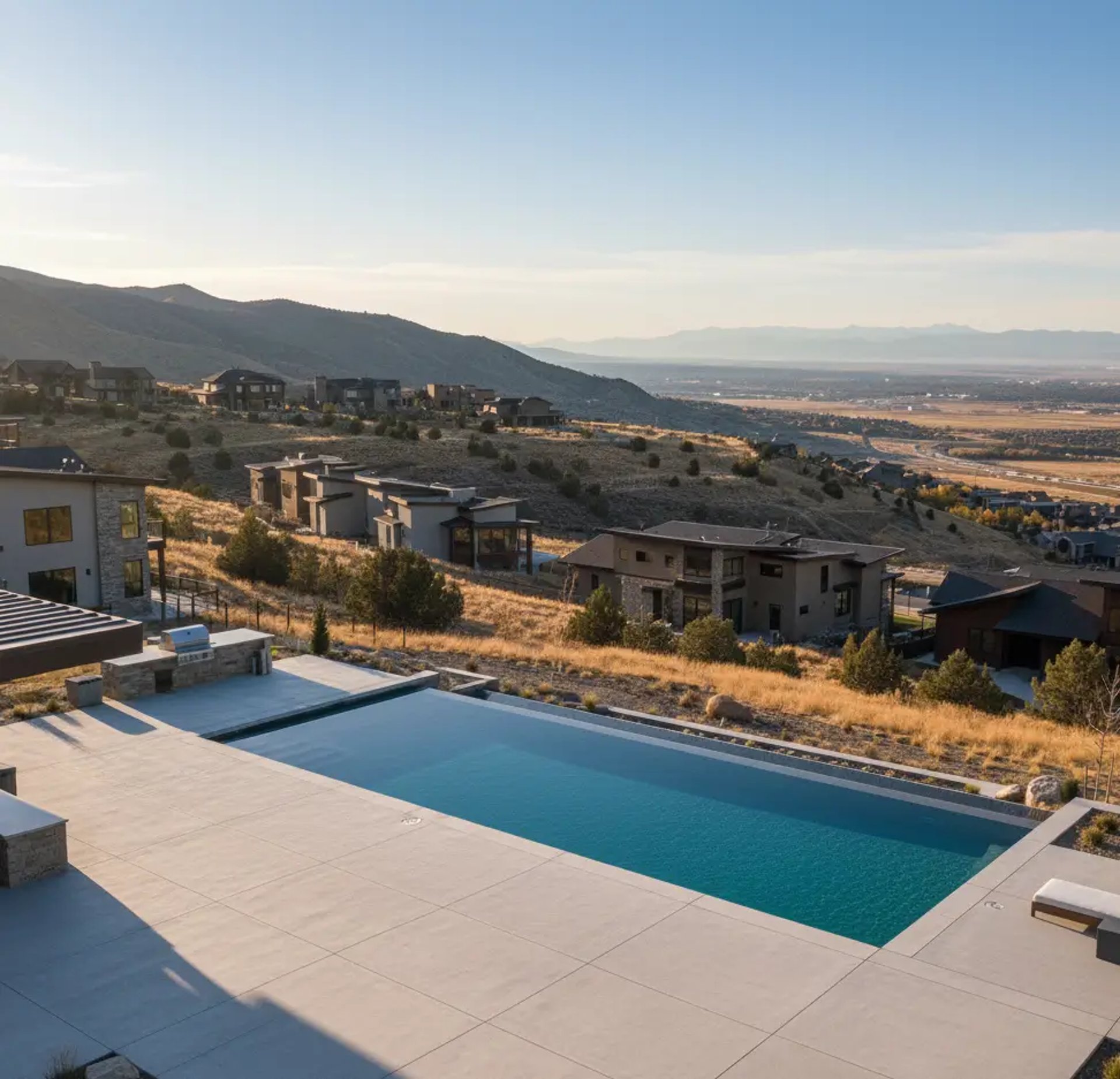 A concrete pool deck with an overlooking neighborhood of Eagle Mountain residential area