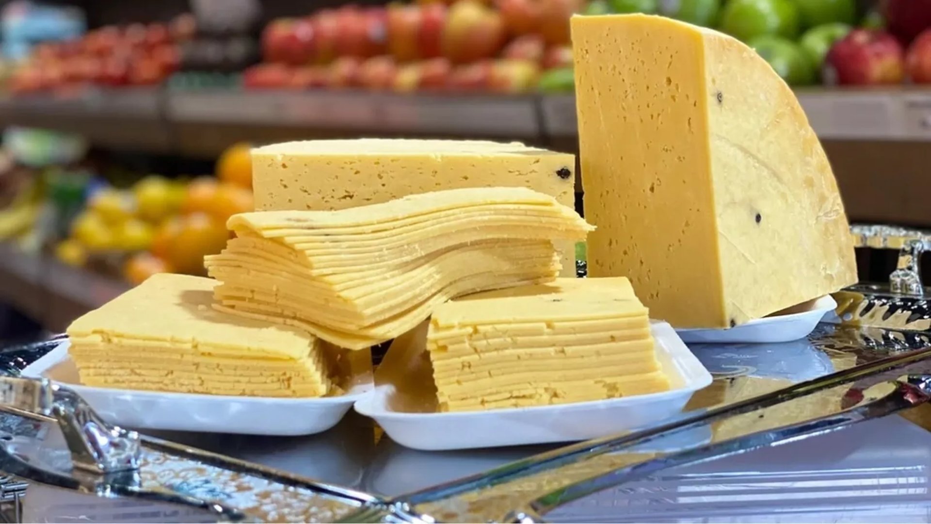 a wooden cutting board topped with cheese and fruit