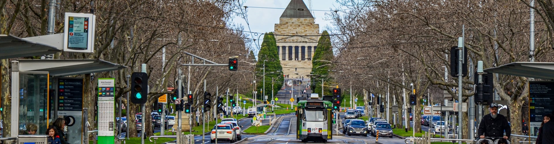 A tram on St Kilda Road in Melbourne with the Shrine of Remembrance in the background