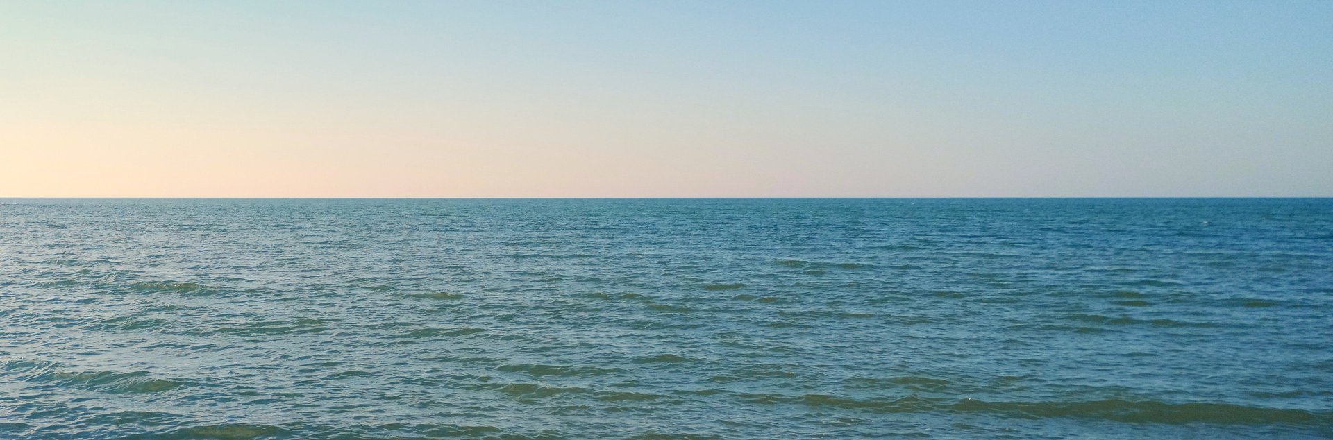 body of water under blue and white sky at daytime