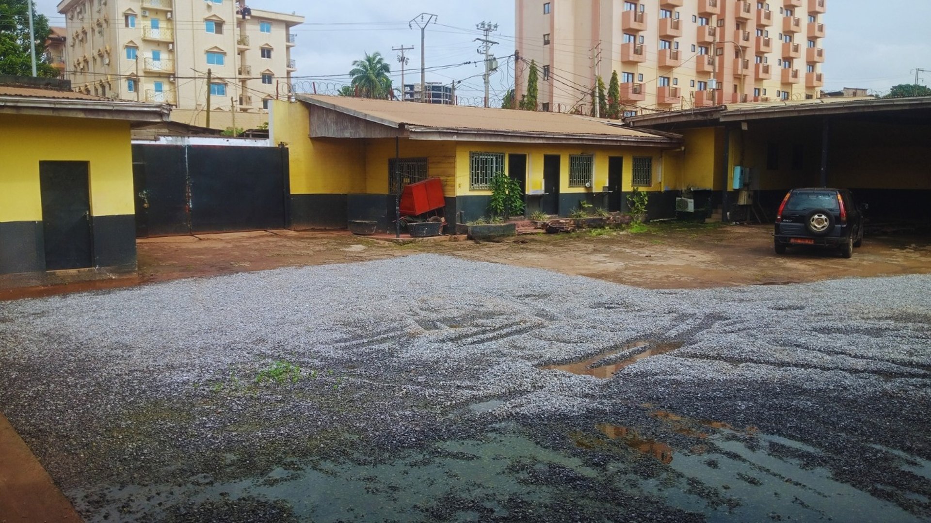 a group of cars parked in a parking lot with buildings in the background