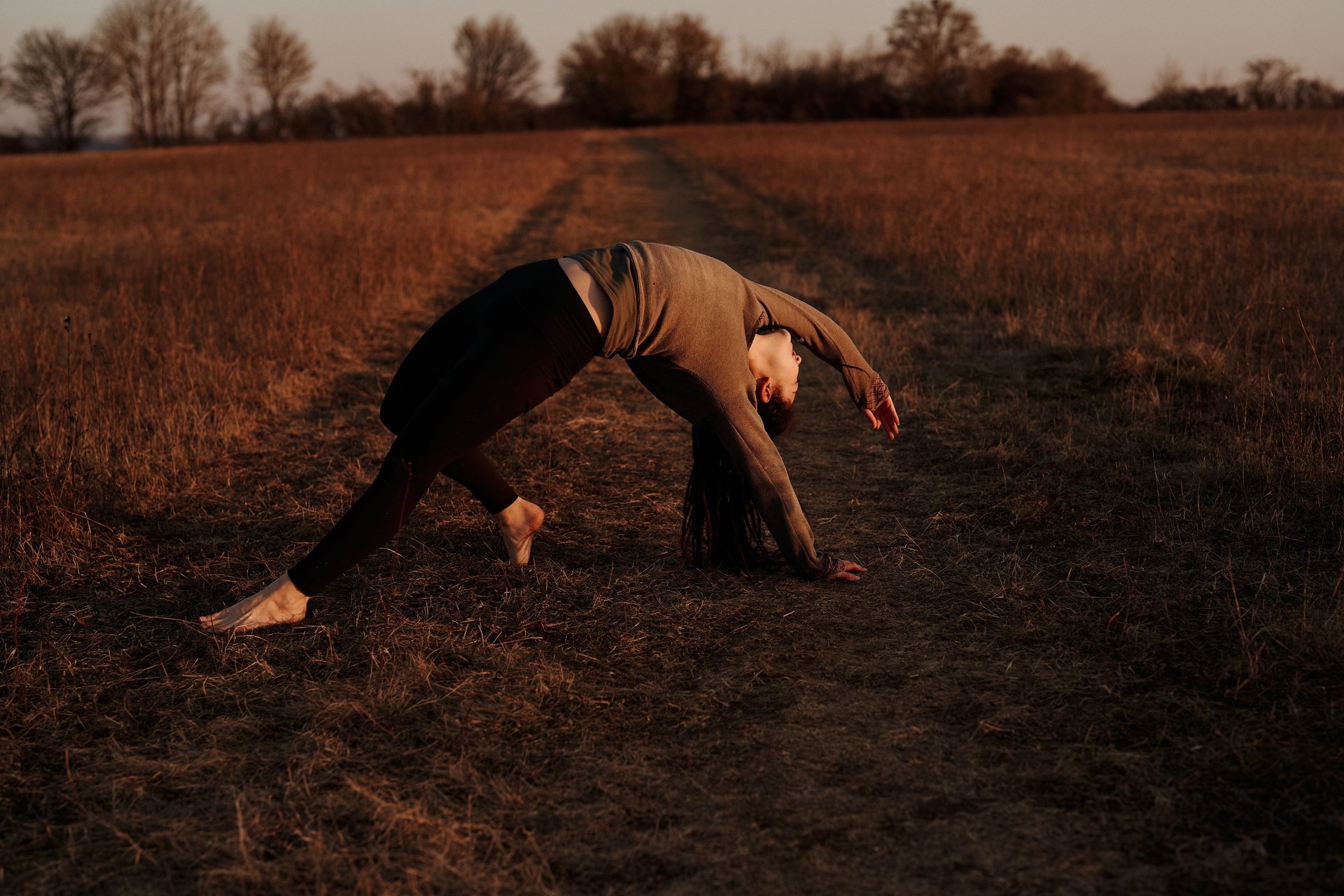 woman in black tank top and gray leggings doing yoga