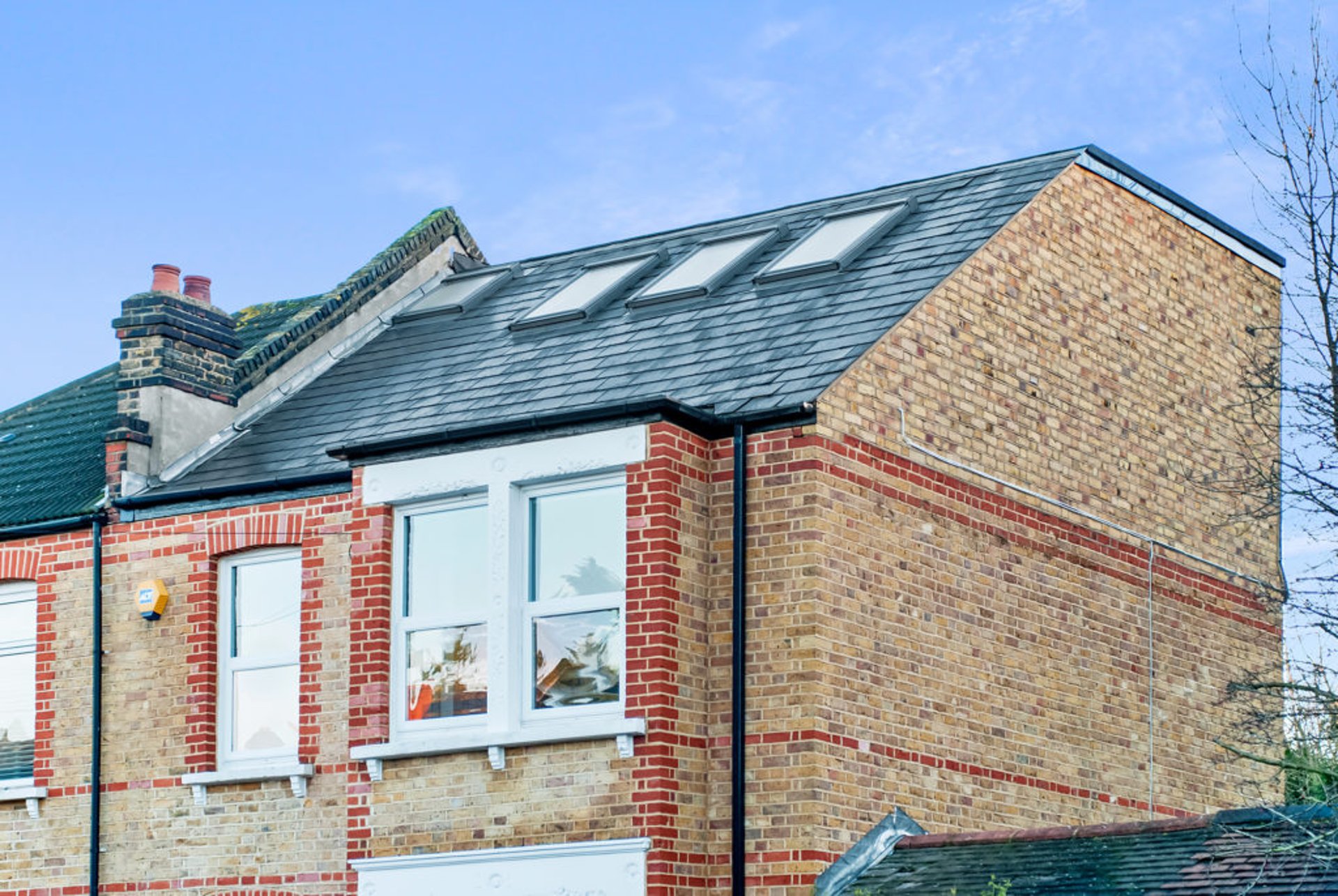 Brick building with white windows and paved path.