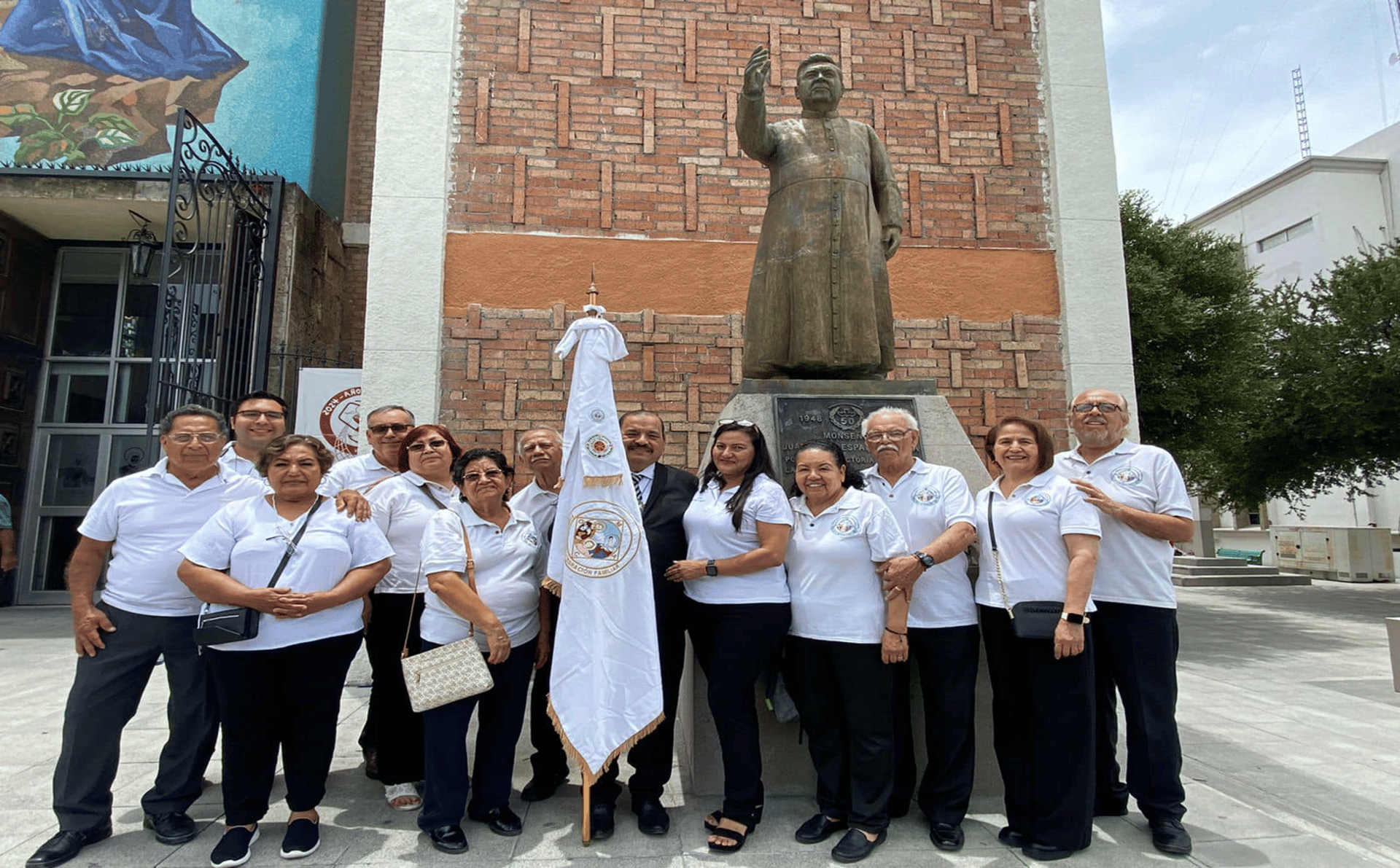 groom and bride kneeling in front of priest raising The Holy Sacrament