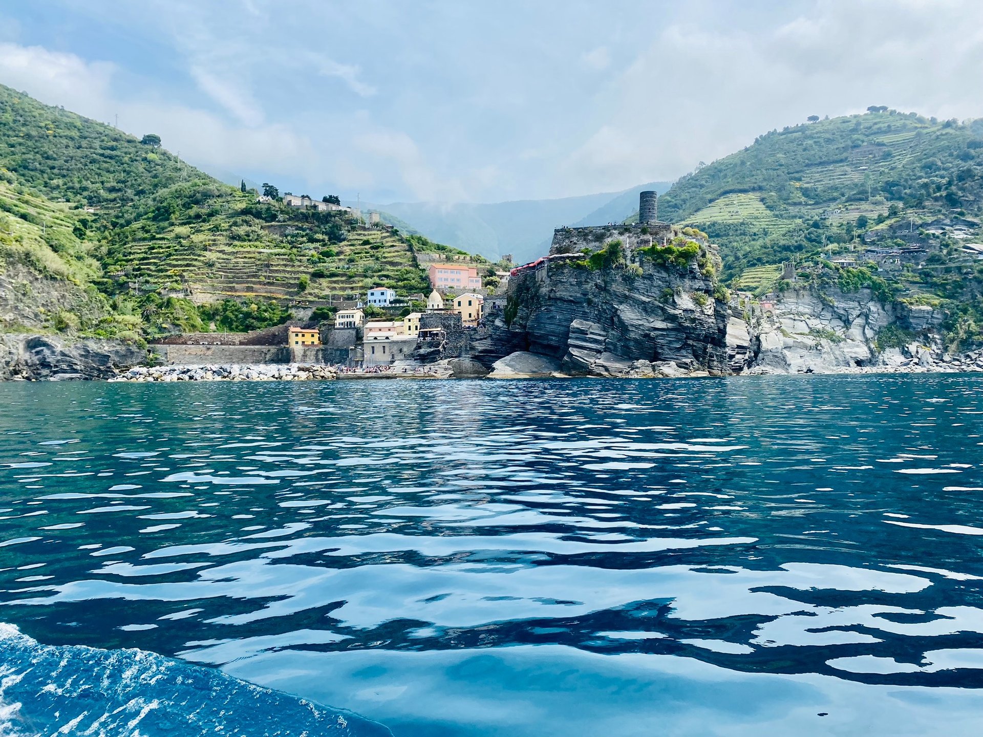 road between green grass field near mountains under blue and brown sky at golden hour
