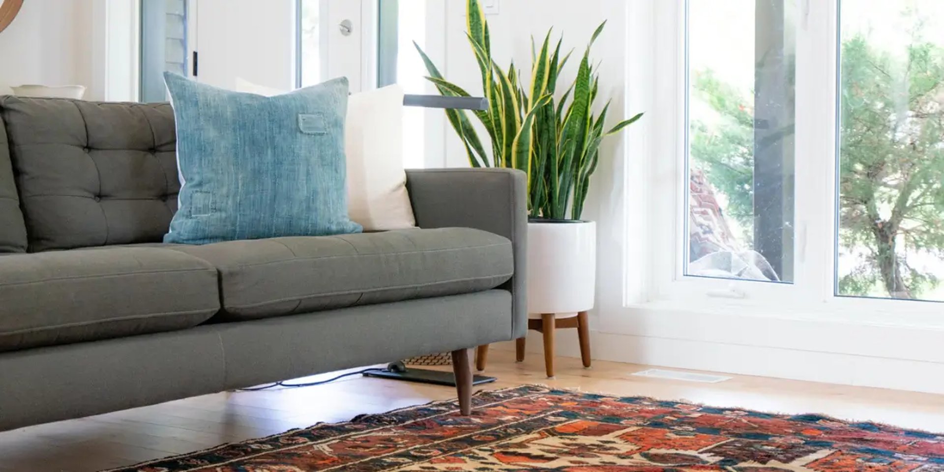 teal 2-seat couch and red area rug