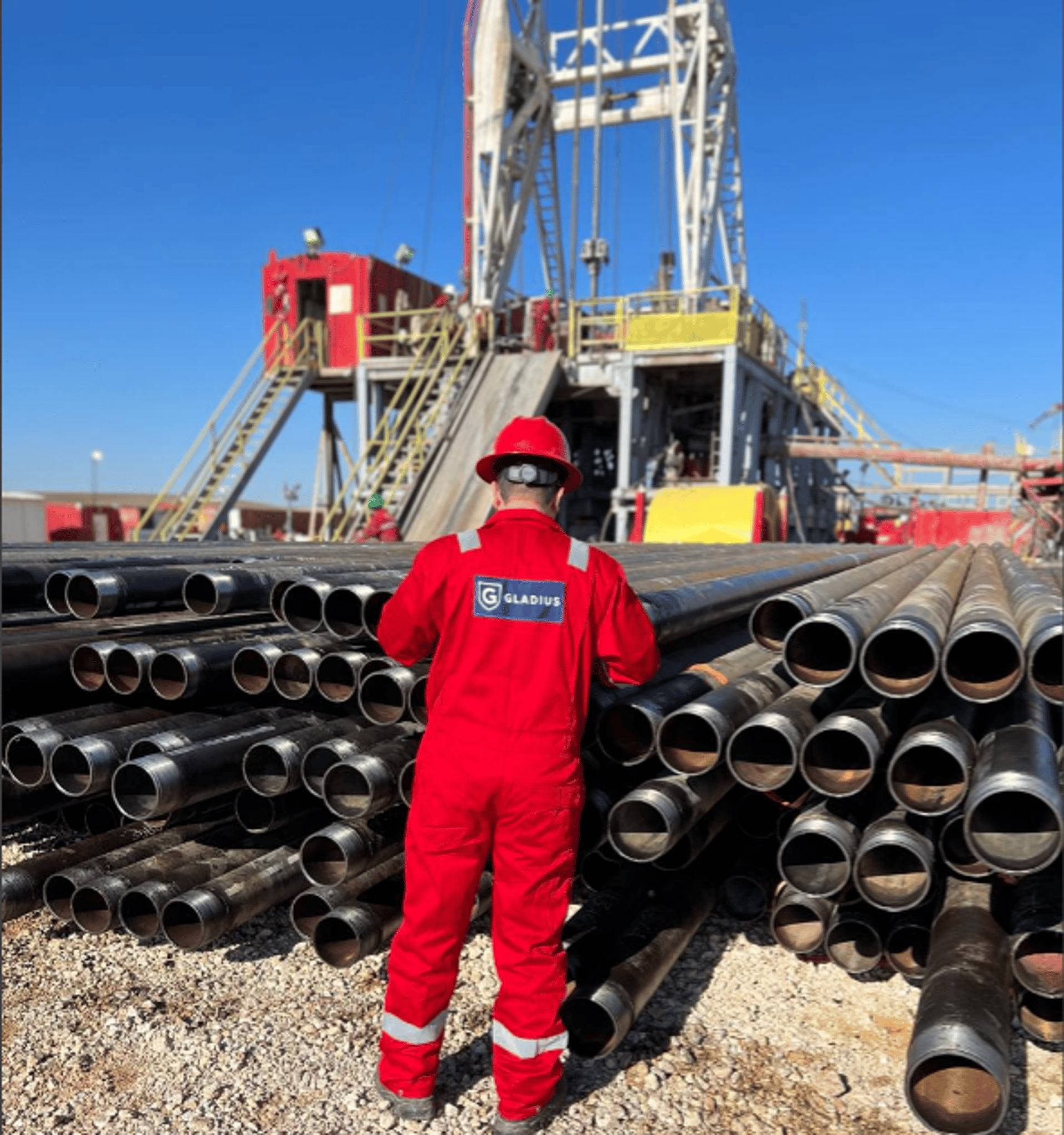 a drilling rig in a field with trees in the background